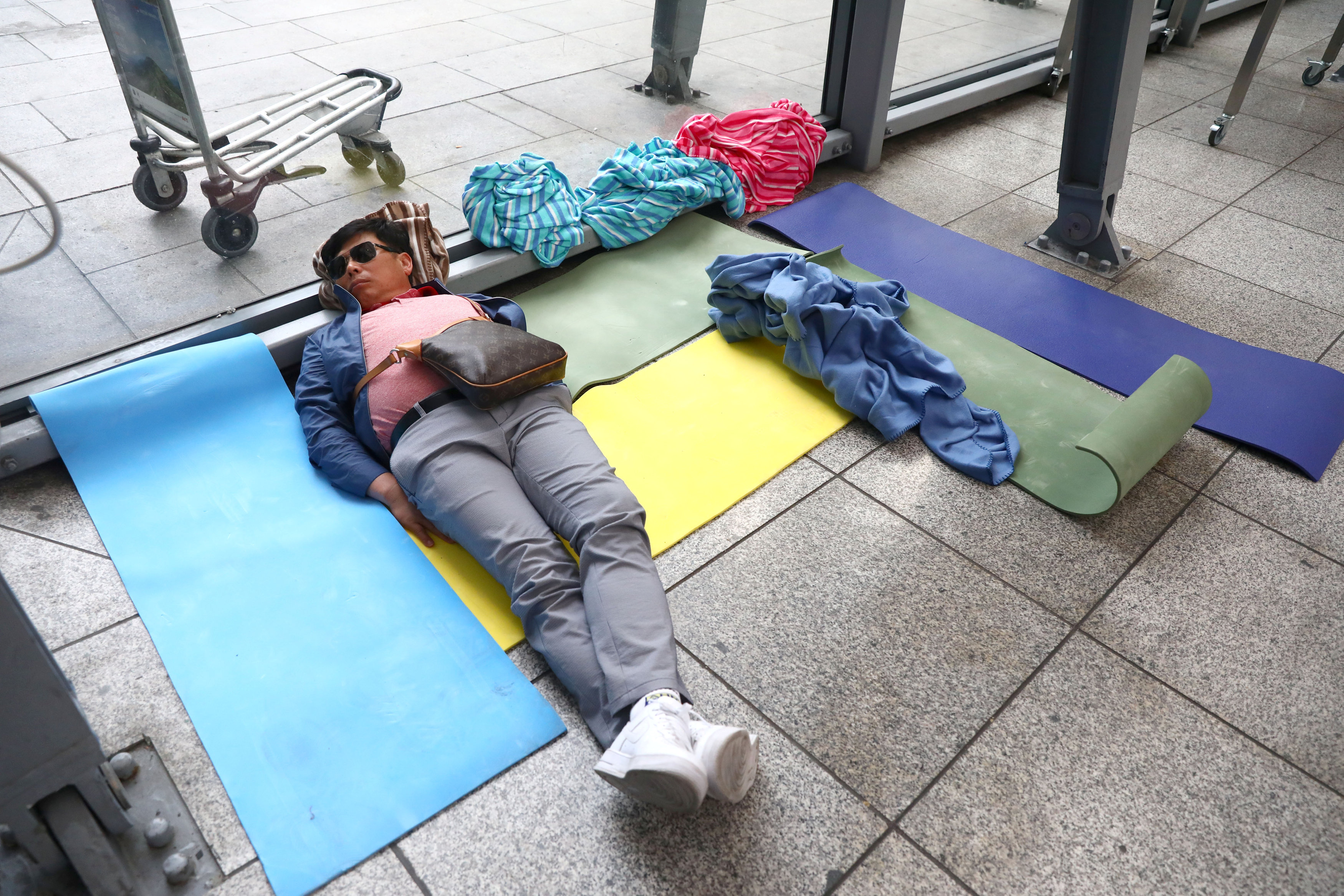 رجل ينام على الأرض فى مطار بريطانى
