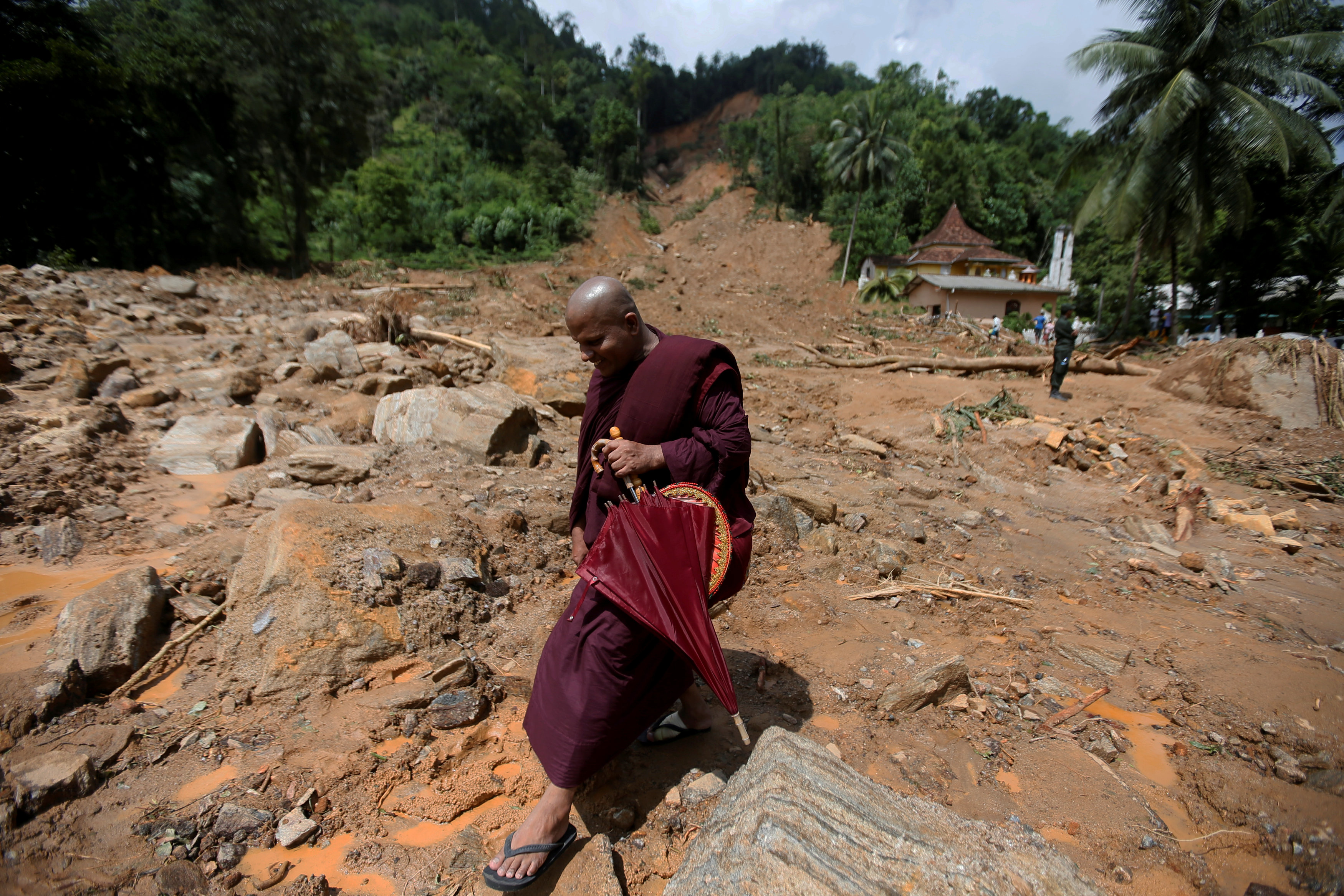 راهب يسير وسط الأنقاض بعد السيول فى سريلانكا