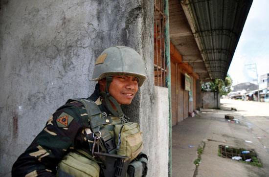 أحد عناصر الجيش الفلبينى يسير وسط الشوارع لتطهير إحدى مدن الجنوب من المتشددين