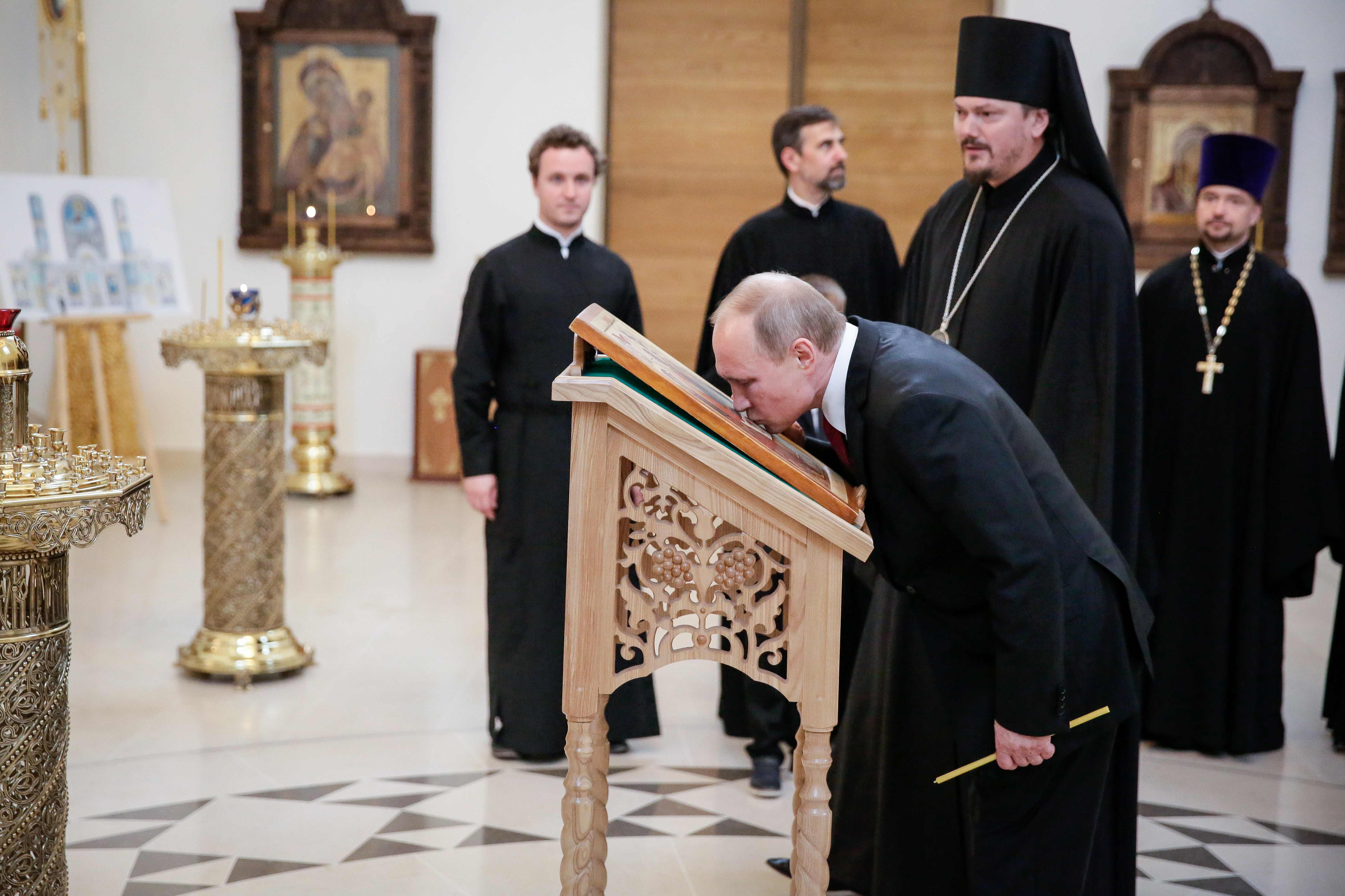 بوتين يقبل رمزا للثالوث المقدس فى كنيسة سانت ترينيتى بباريس