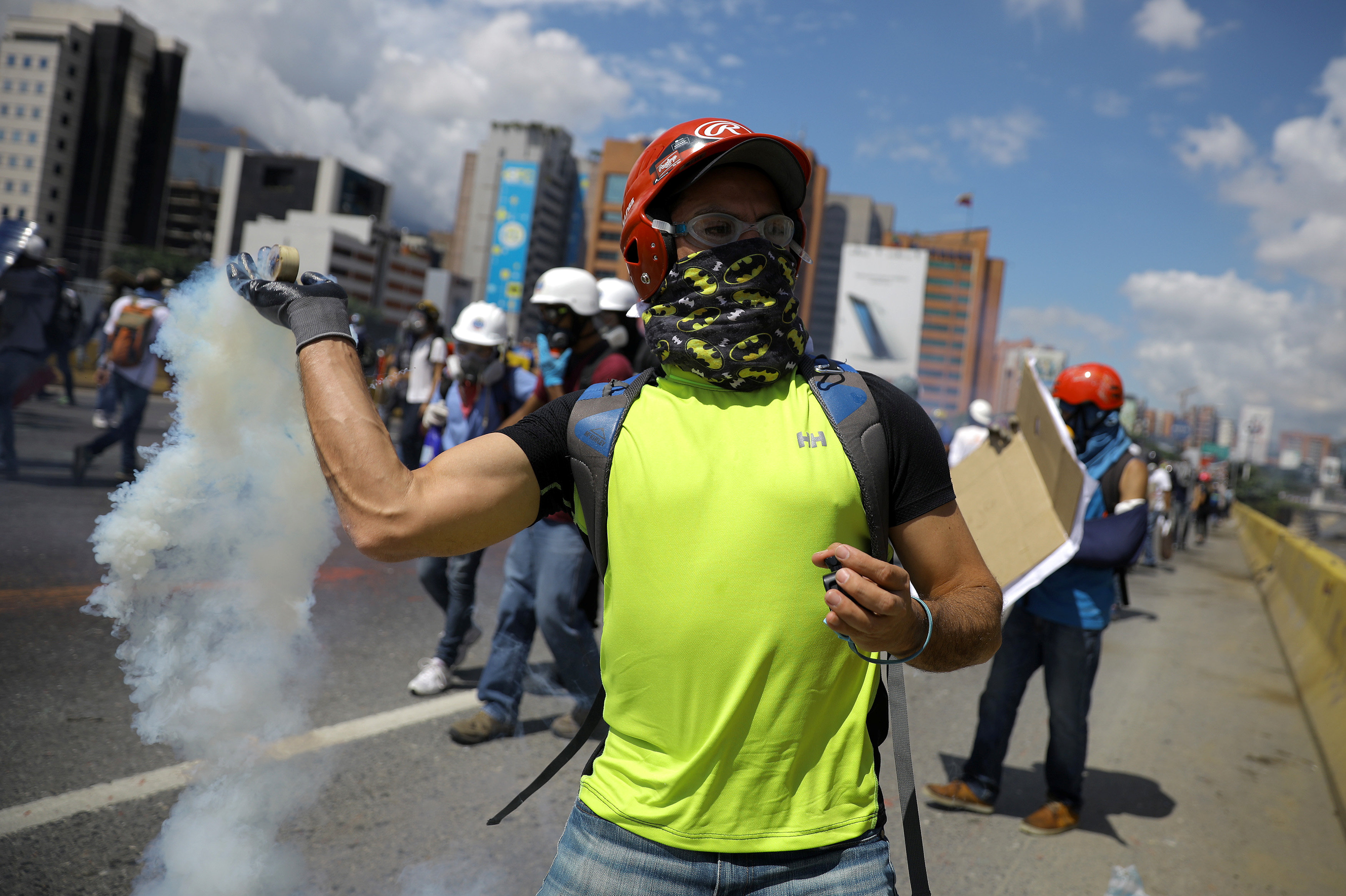 متظاهر يطلق الغازات المسيلة على قوات الشرطة