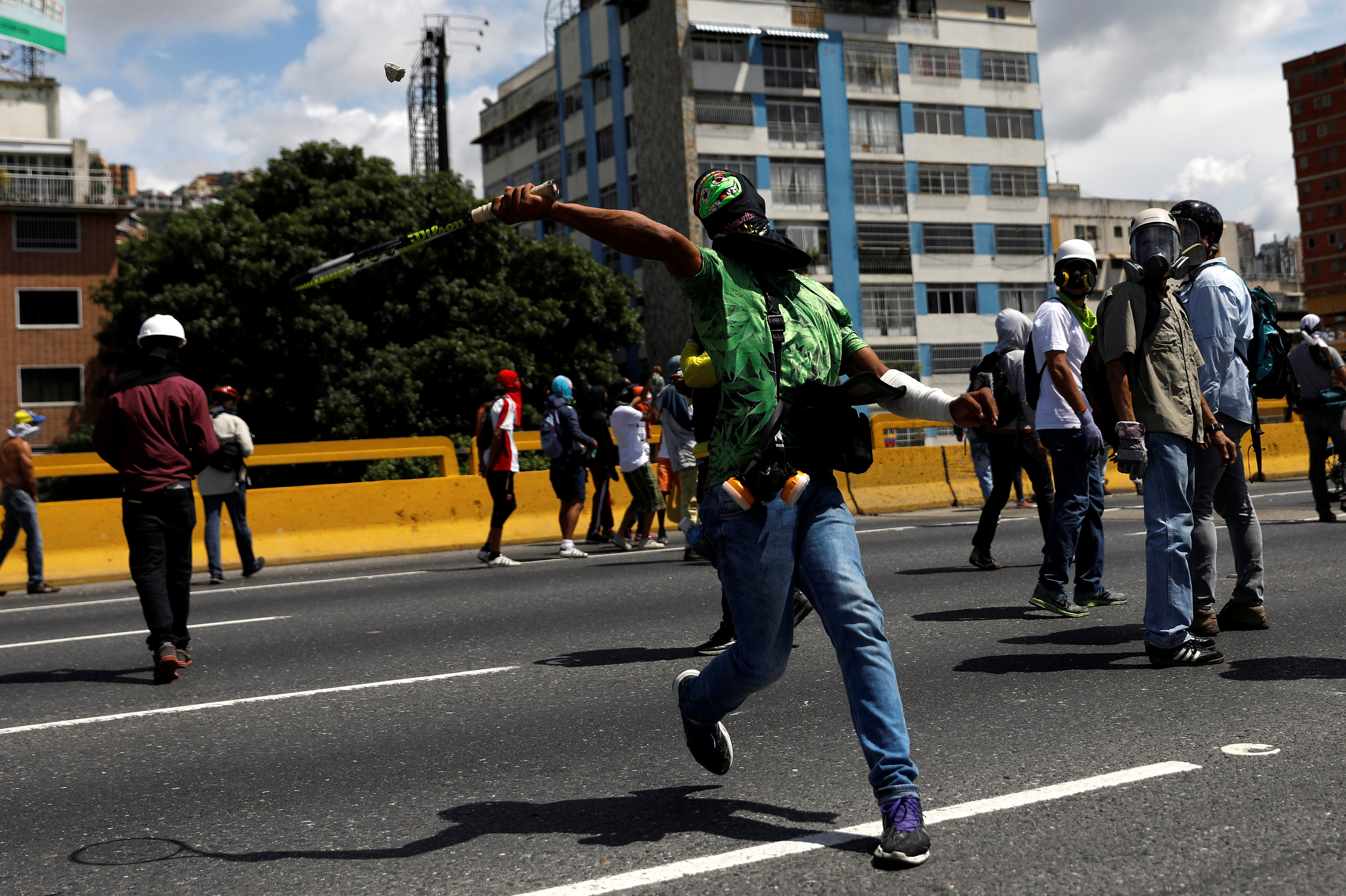 متظاهر فنزويليى يستخدم العصا فى مواجهة الشرطة