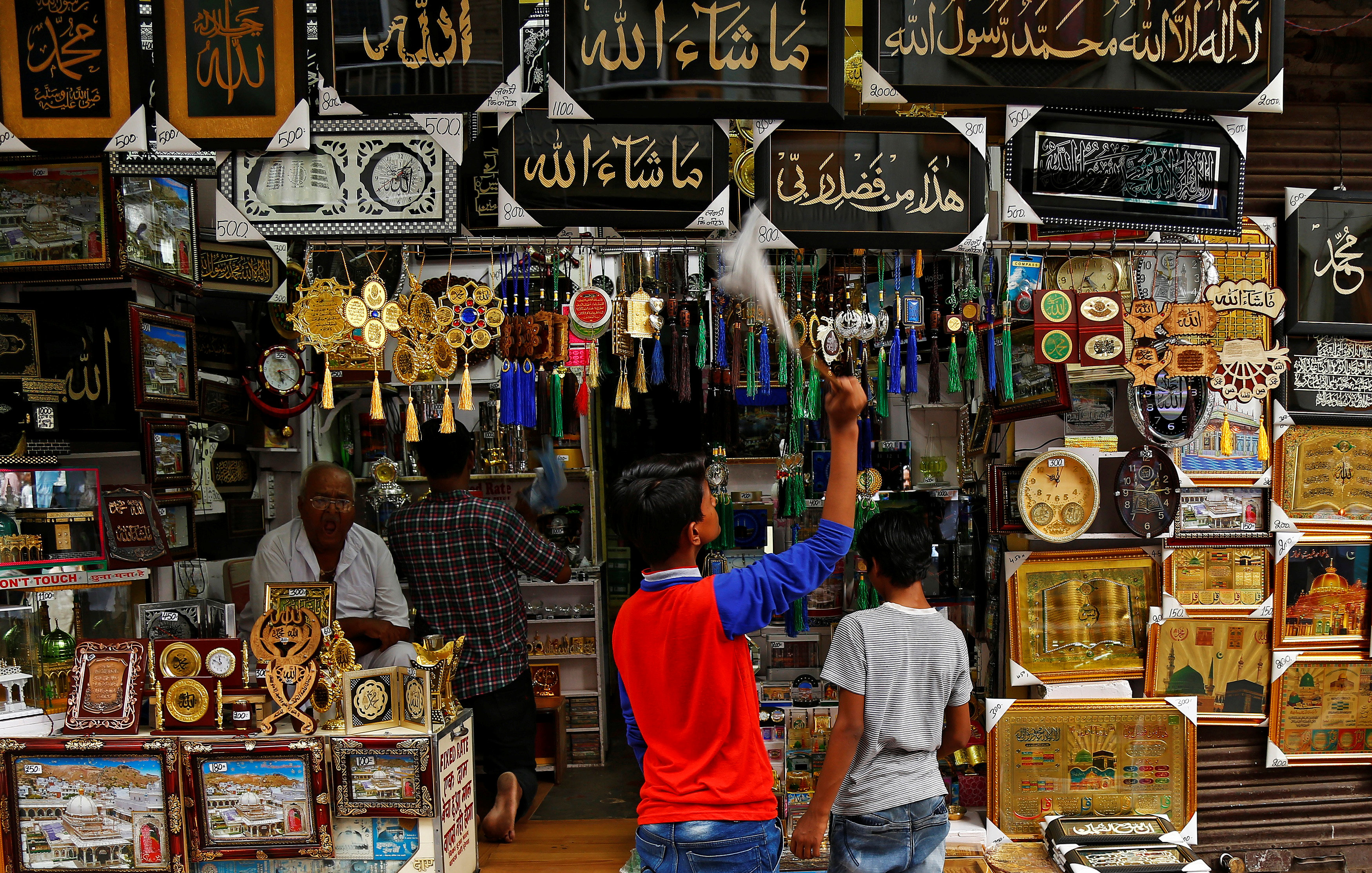 صبي ينظف الصور الدينية للبيع في متجر بأجمير فى الهند