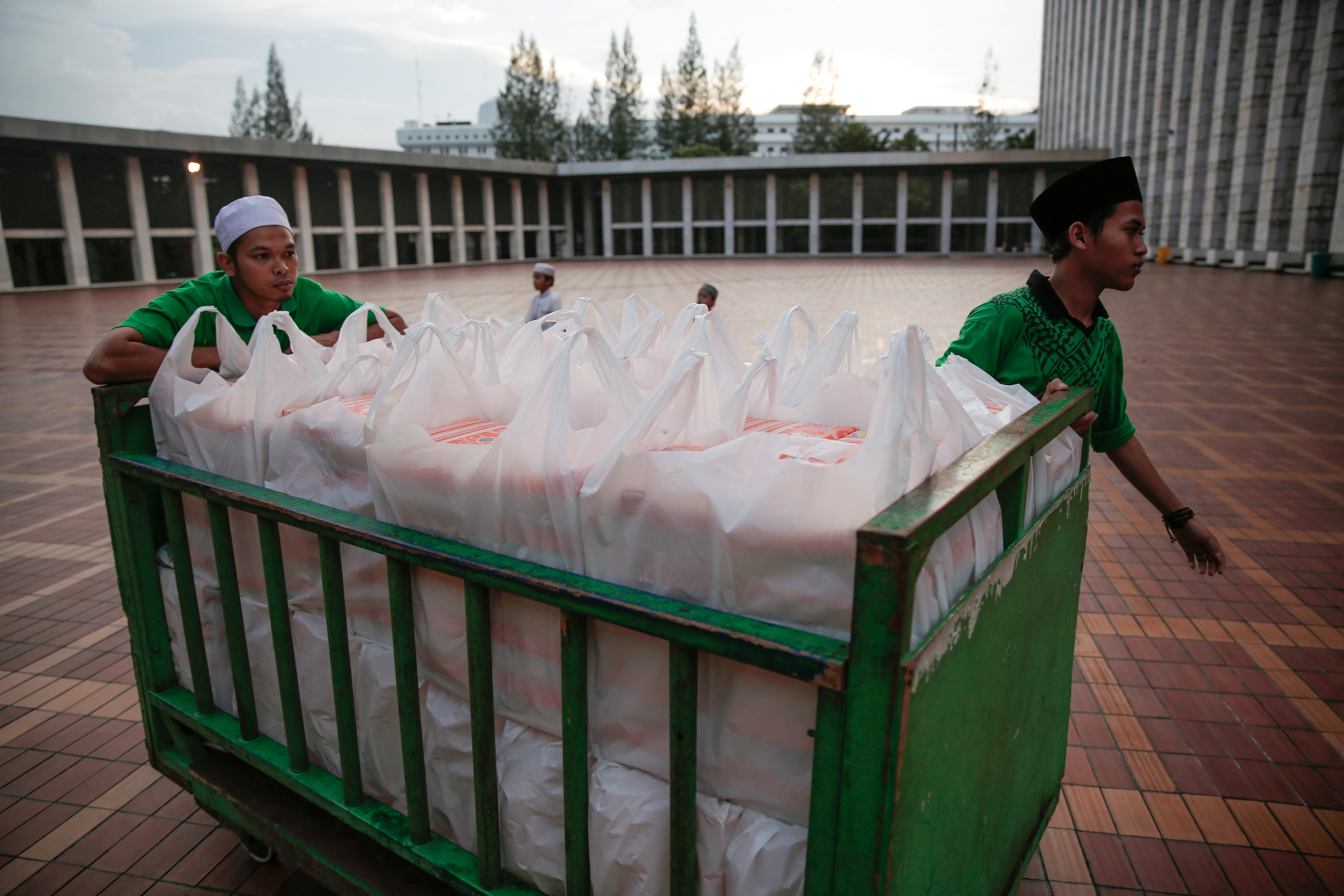 شباب إندونسيون يحملون عبوات الإفطار الجماعى