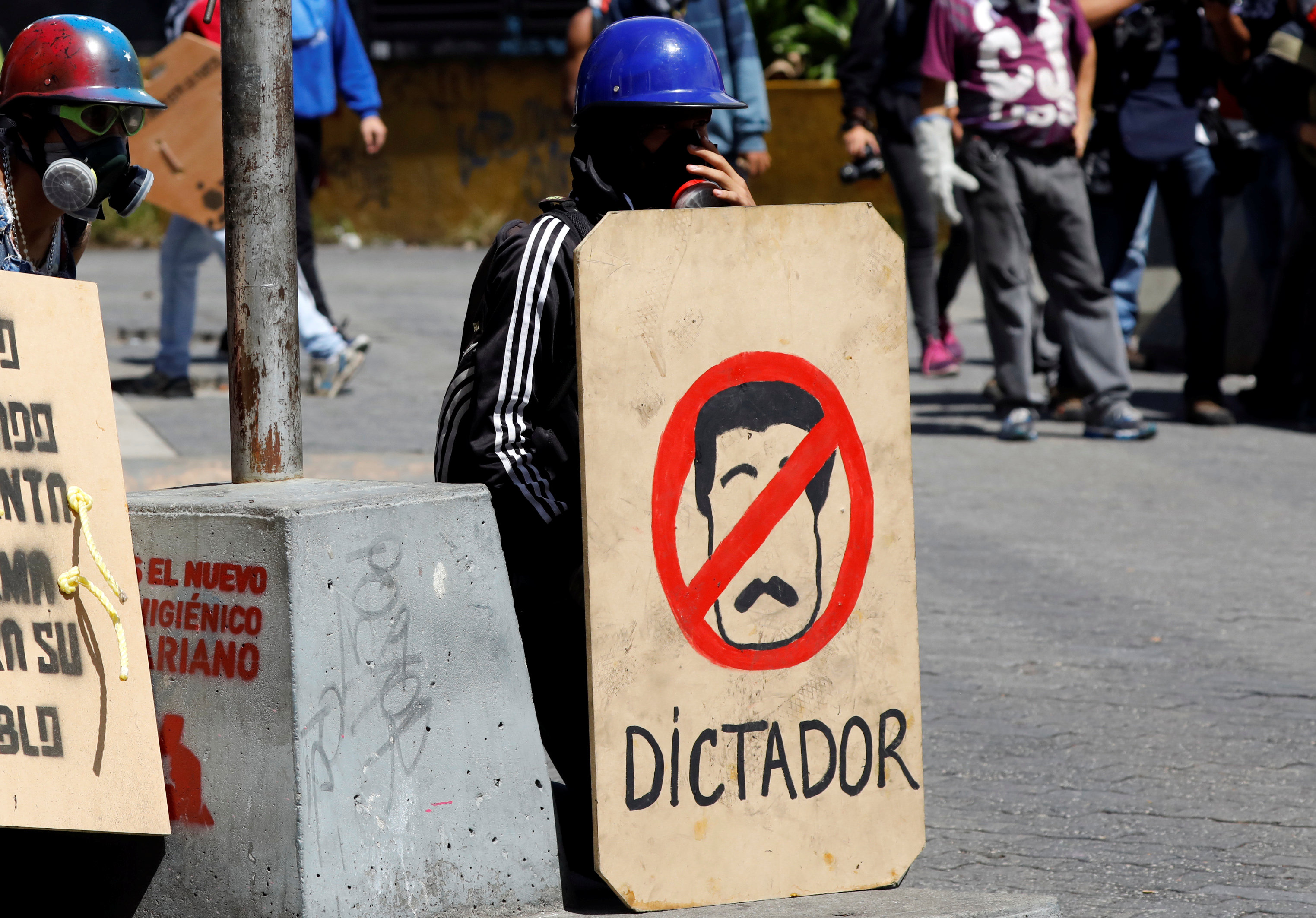 متظاهر يحمل لافتة معارضة للرئيس مادورو