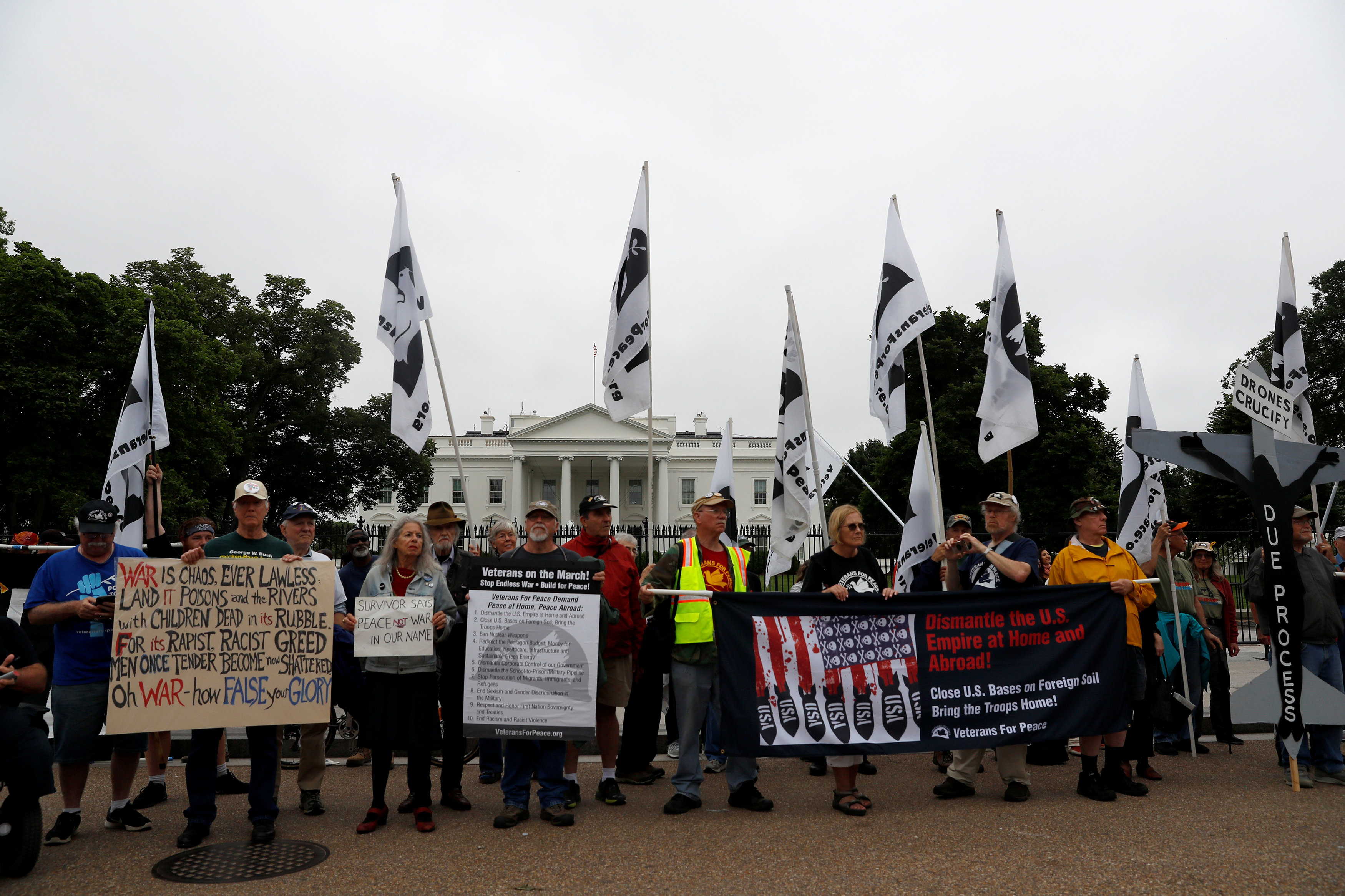 المتظاهرون يحملون لافتات إعتراضا على سياسة الرئيس الأمريكى
