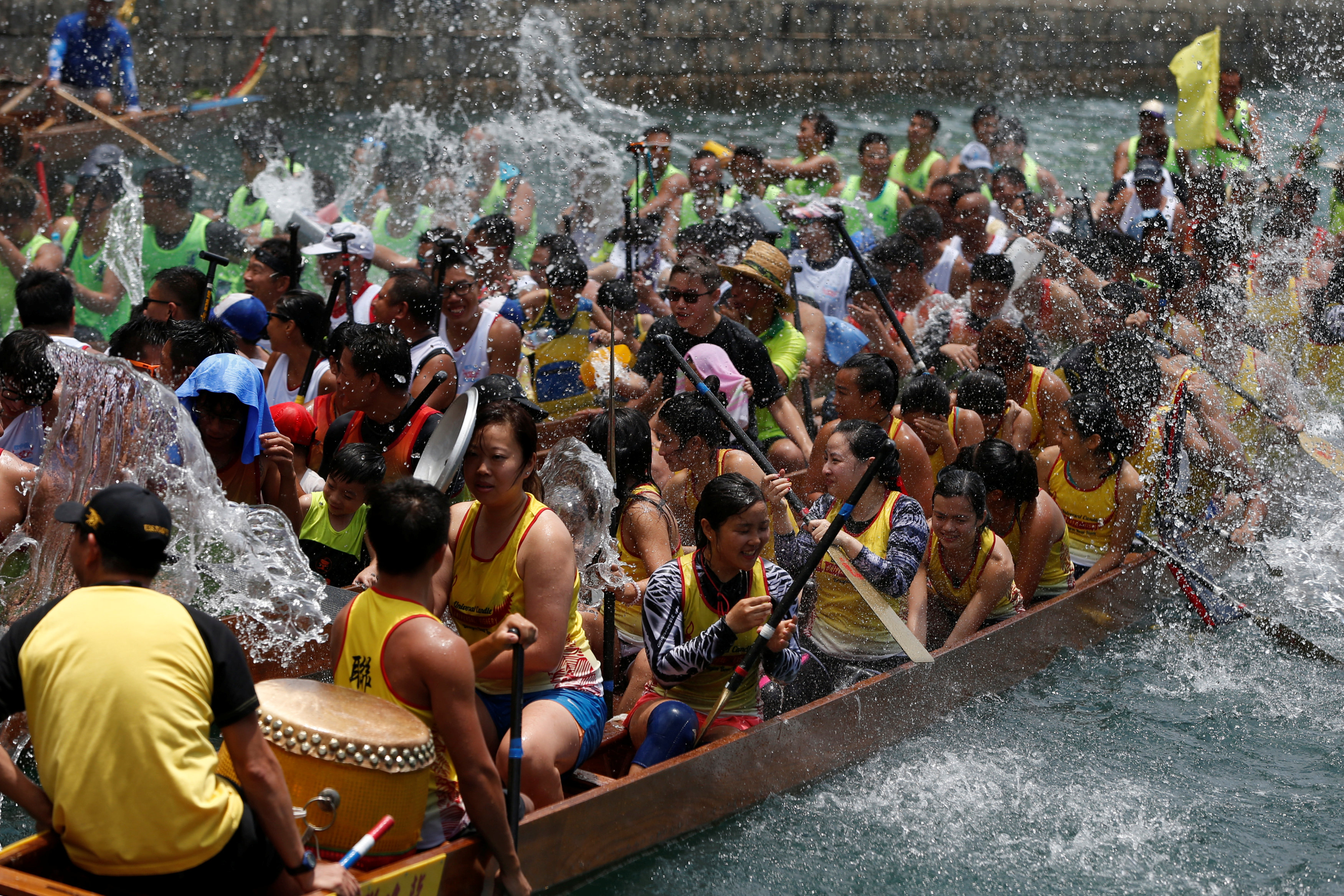 المشاركون فى رش المياه خلال حفل مهرجان قوارب التنين