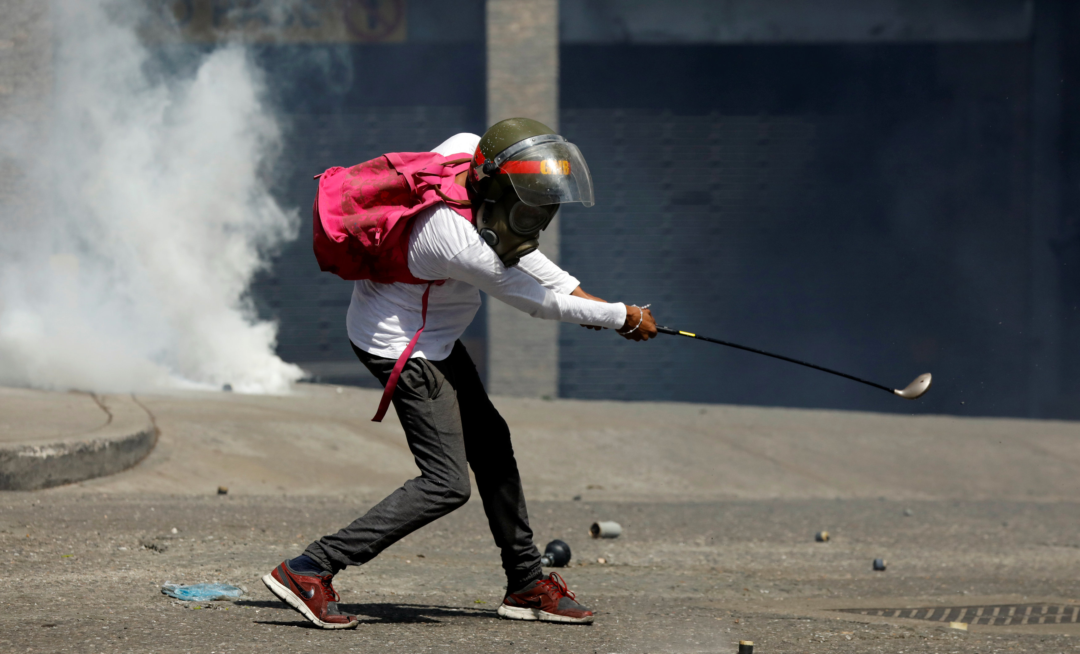 متظاهر فنزويلى يحمل عصا ويرتدى قناع