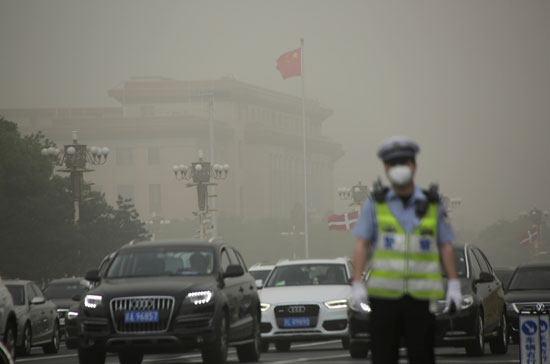 أحد-عناصر-الشرطة-الصينية-يرتدى-كمامة-بسبب-العاصفة-الترابية
