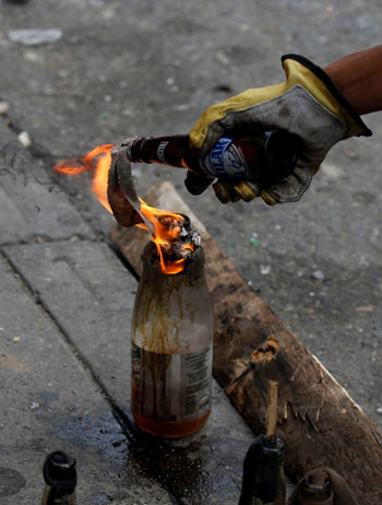 متظاهر يشعل زجاجة مولوتوف