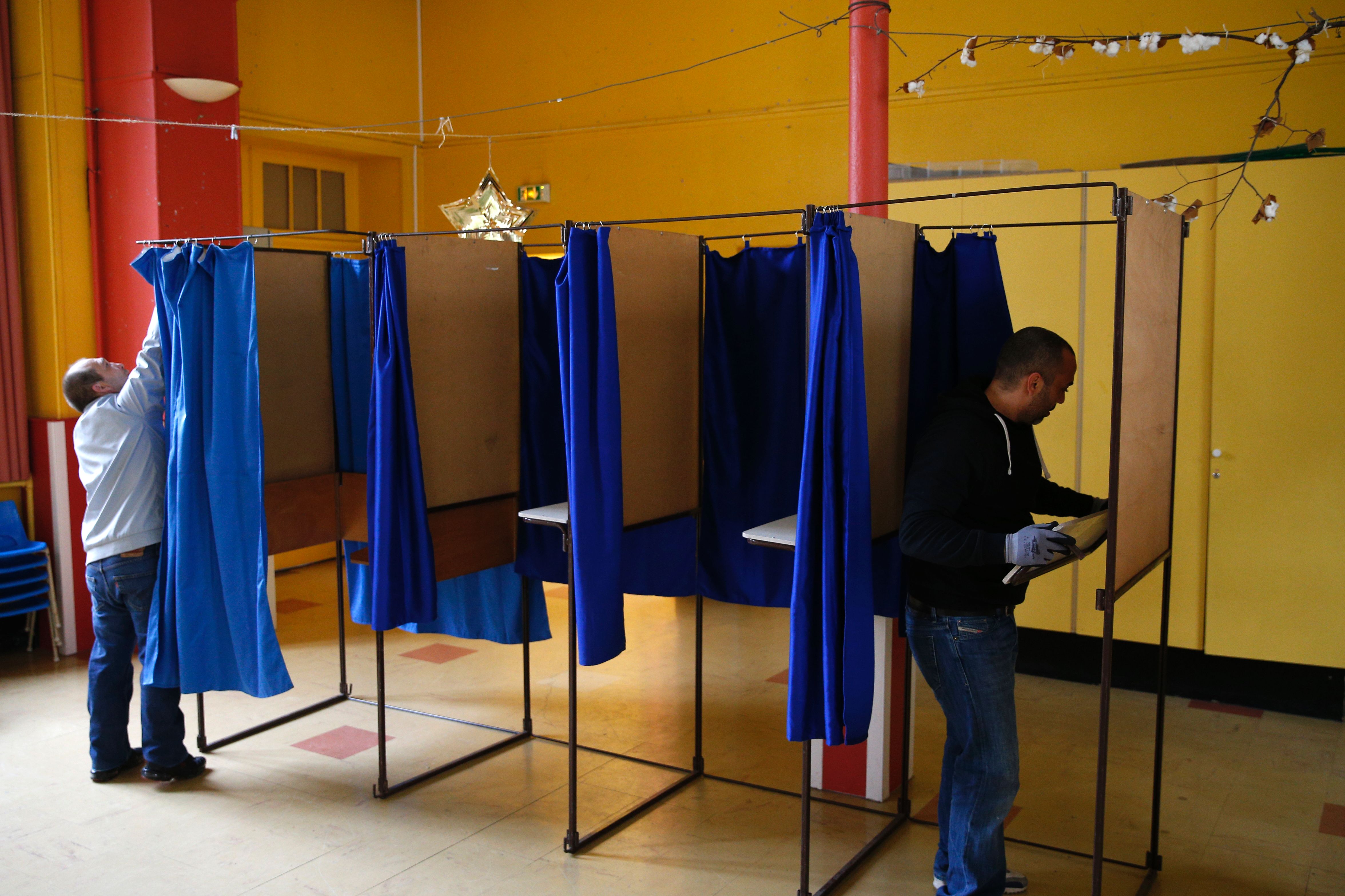 عمال يركبون ستائر أماكن التصويت للانتخابات الفرنسية