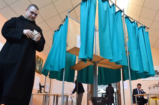 راهب يسلم ورقة اقتراع فى انتخابات الرئاسة الفرنسية