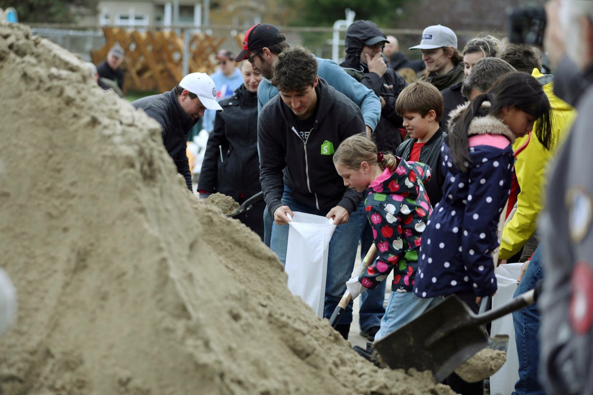رئيس وزراء كندا يساعد المواطنين فى تعبئة الرمال