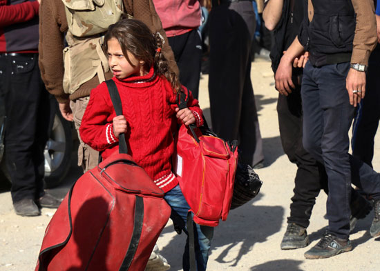 طفلة تحمل حقيبتها لمغادرة حى برزة فى دمشق