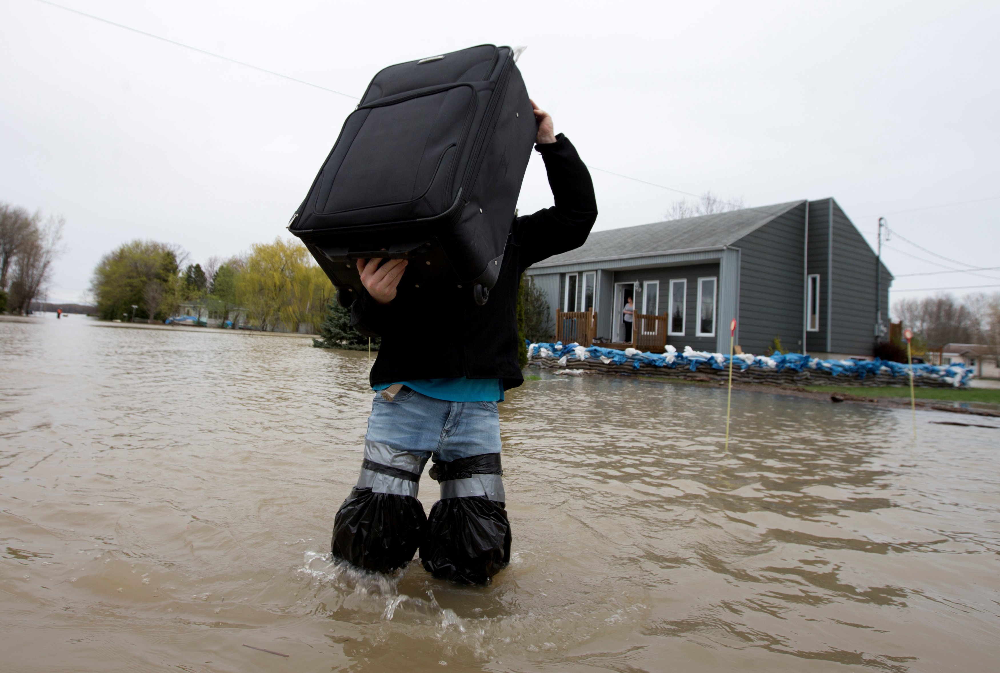 رجل يمشى وسط مياه الفيضانات