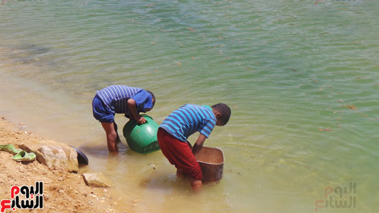  الأطفال يملئون الجراكن من مياه المصارف