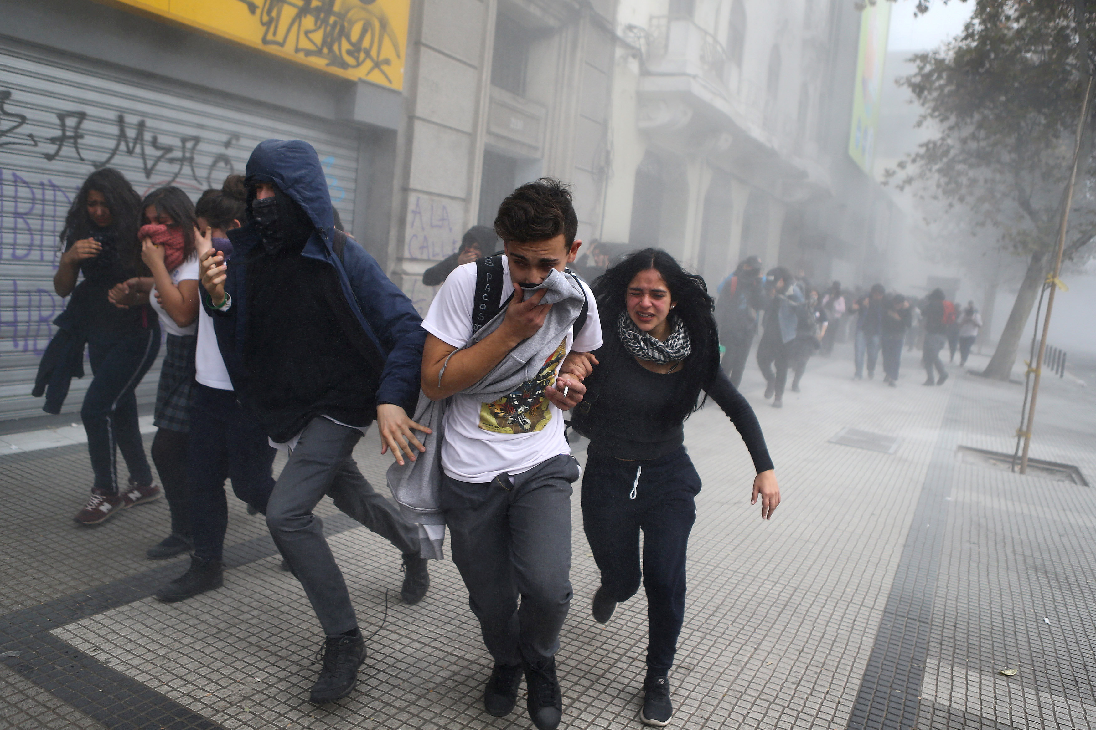 فرار المتظاهرين من الغاز المسيل للدموع