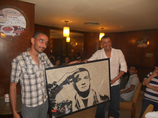 محمد مصطفى مع الشاعر هشام الجخ ولوحة للأخير بالقصاصات
