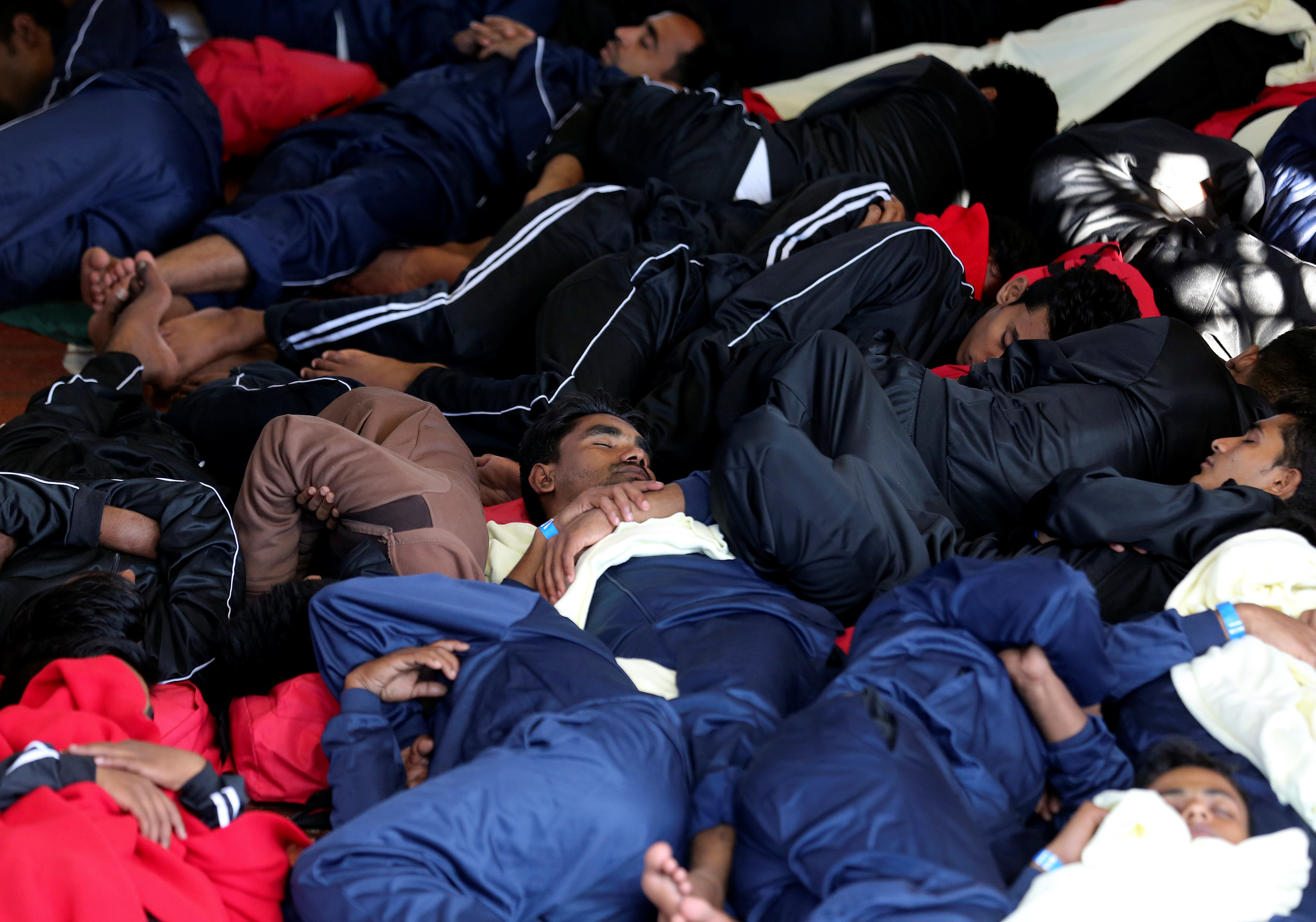 مهاجرون ينامون بعد انقاذهم