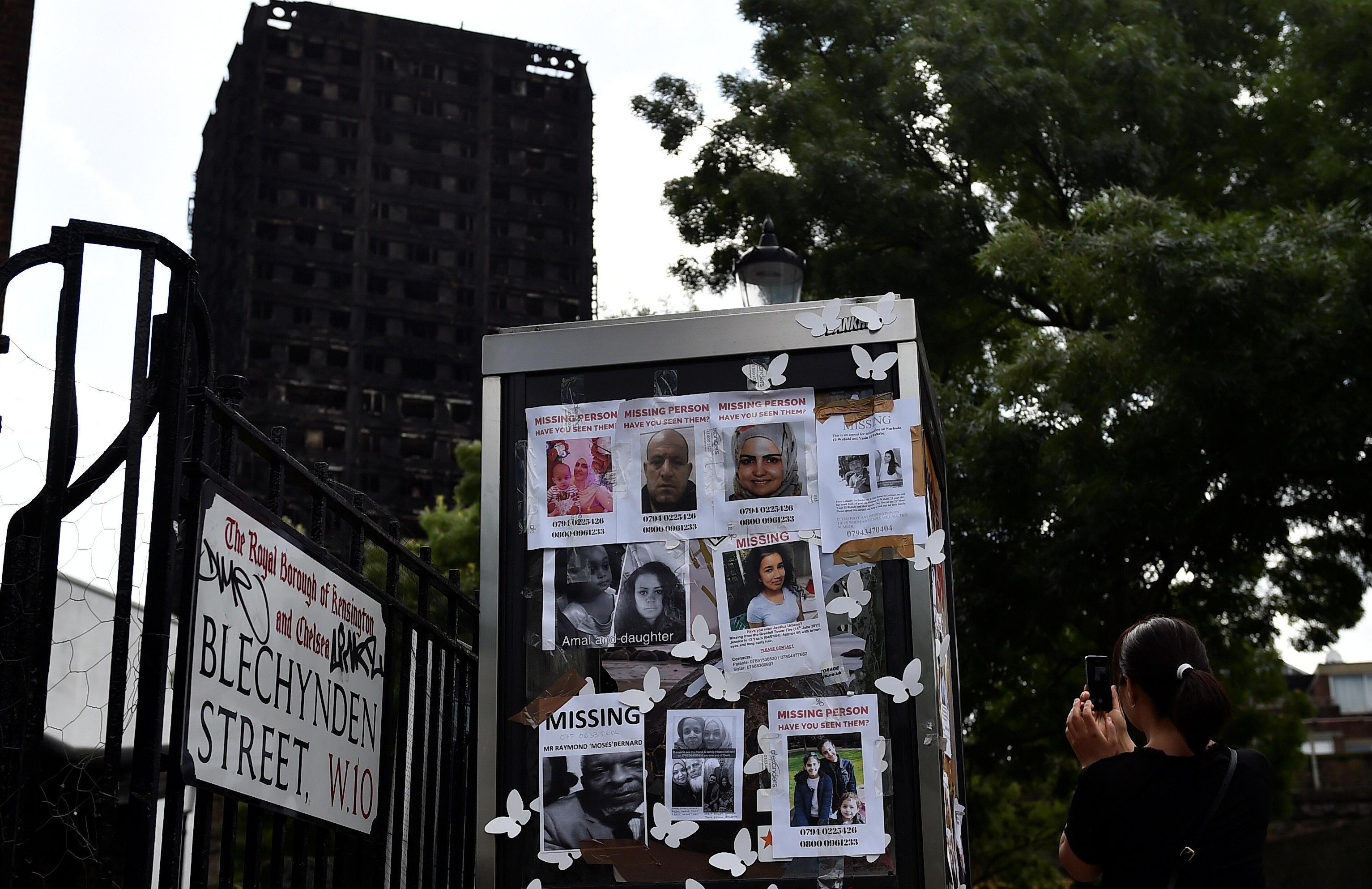 فتاة تلتقط صورة لصور ضحايا البرج المحترق