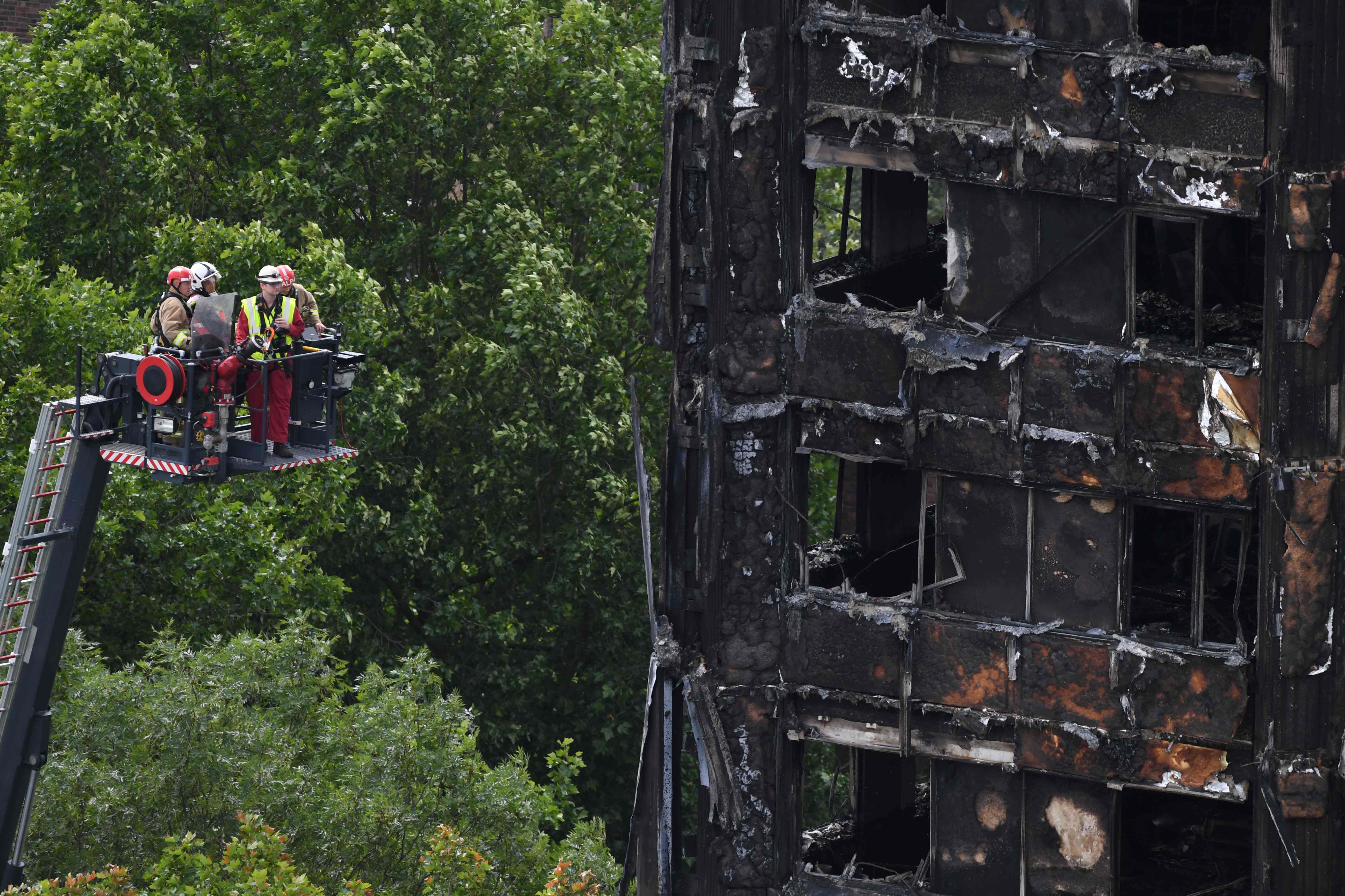 رجال الإنقاذ يبحثون عن ضحايا فى البرج السكنى المحترق