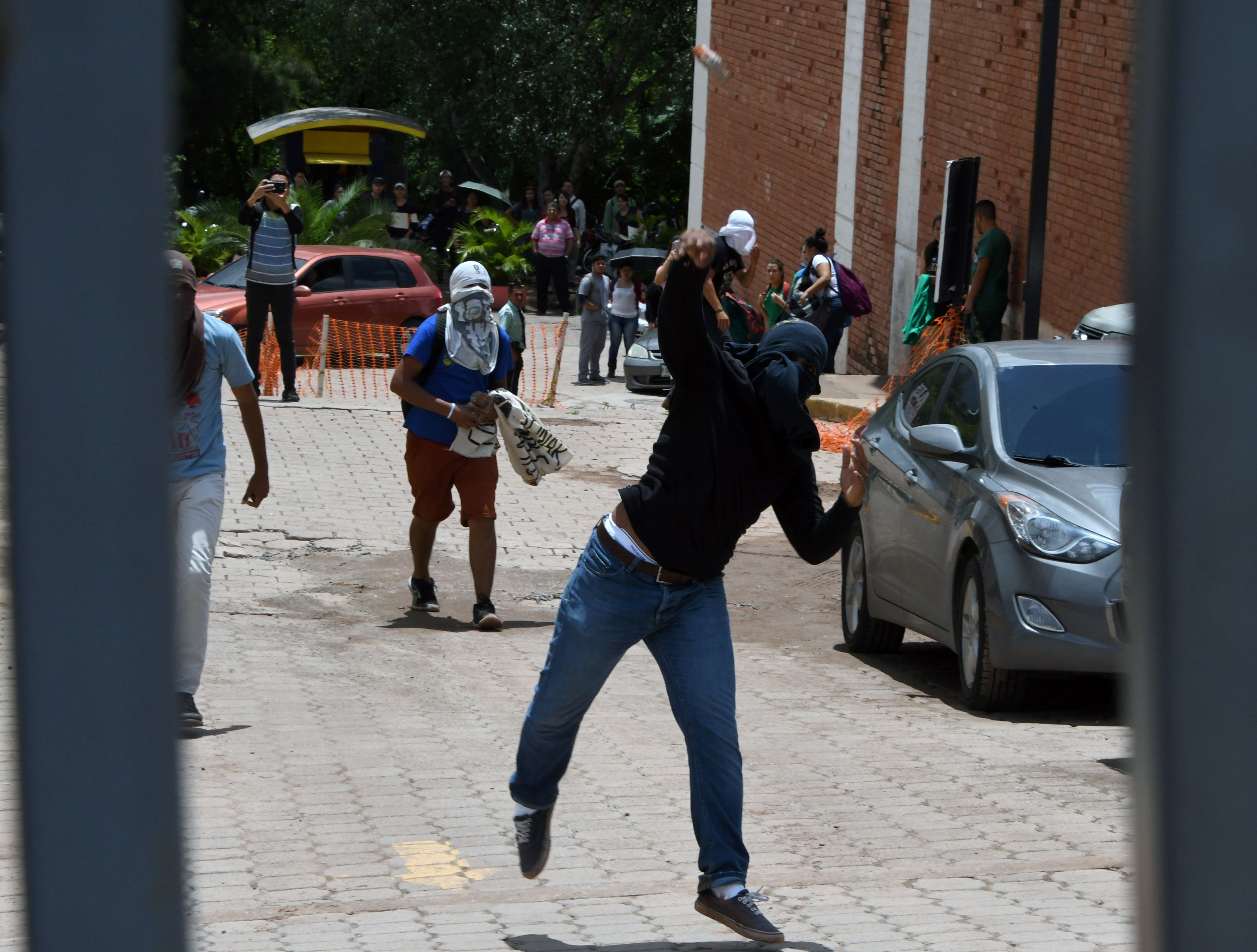 طالب يرشق الشرطة بالحجارة