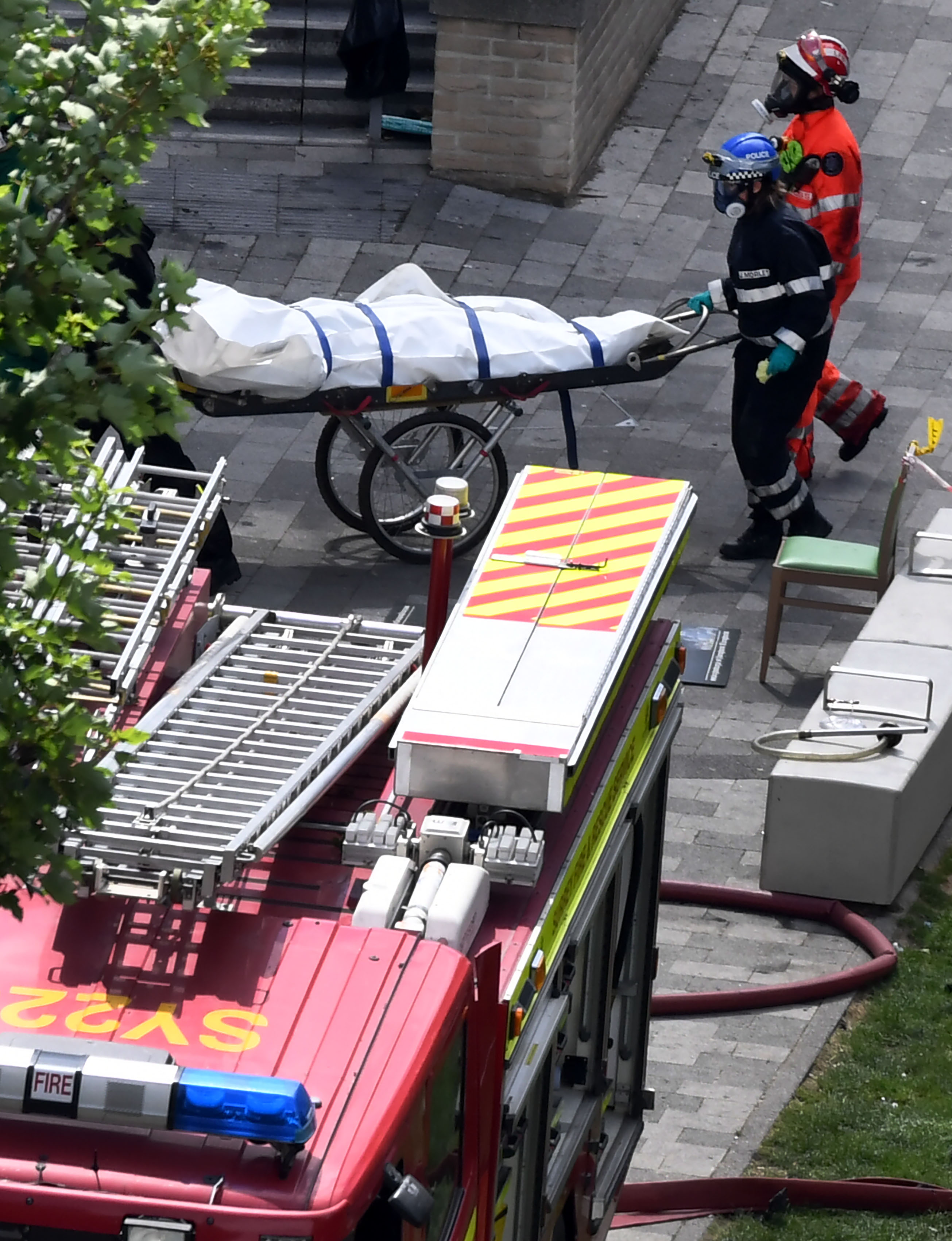 رجال الإنقاذ ينتشلون جثمان أحد الضحايا فى الحريق
