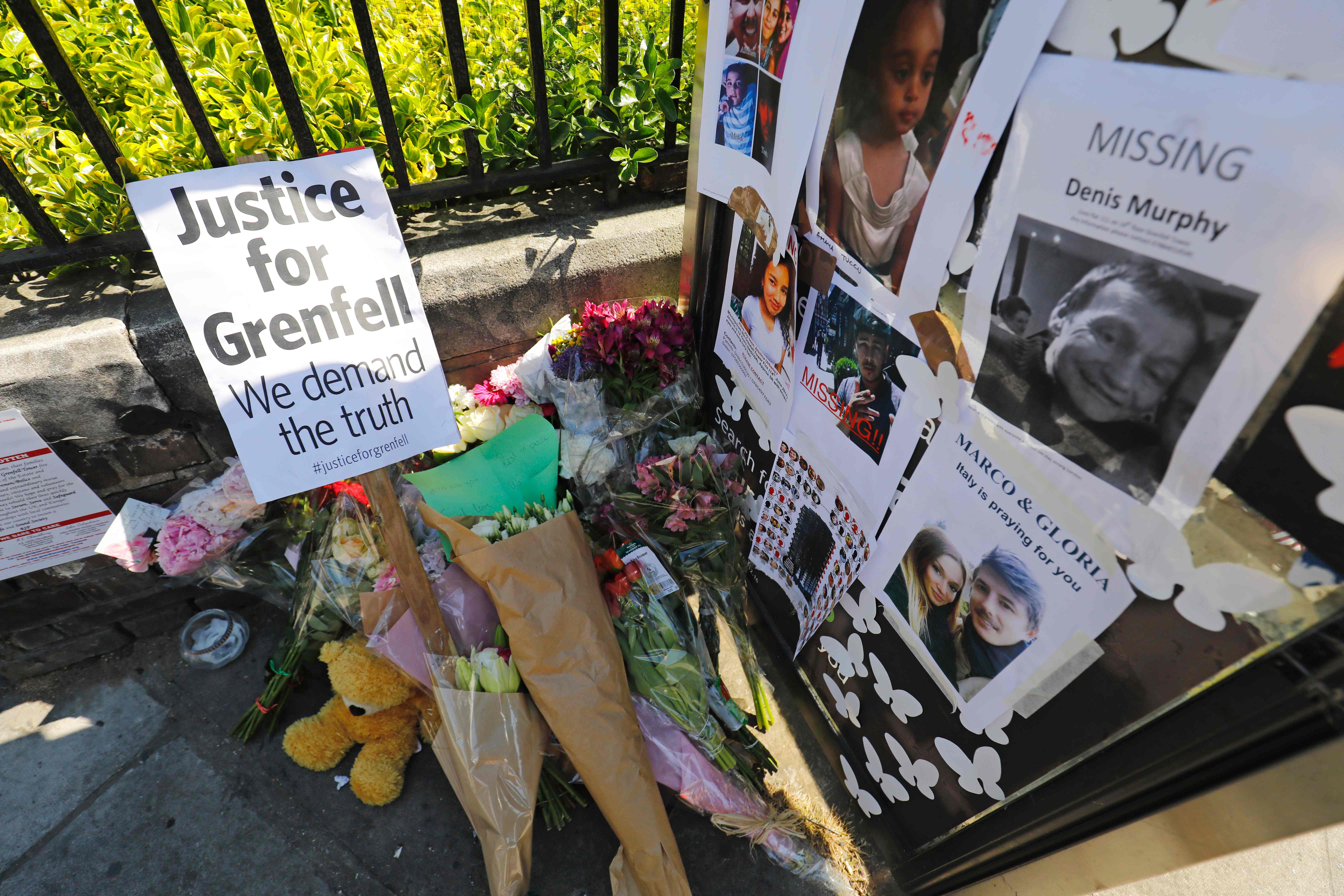 باقات الزهور أمام لافتة تأبين ضحايا الحريق فى لندن