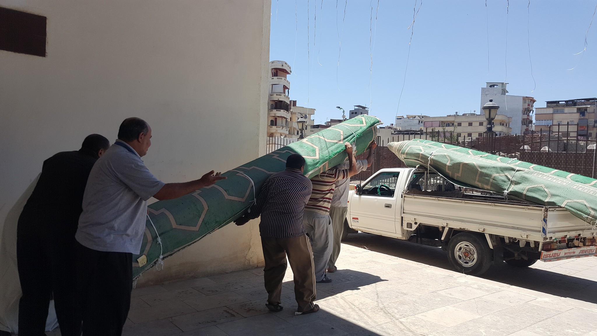 العاملين يحملون سجاجيد المسجد