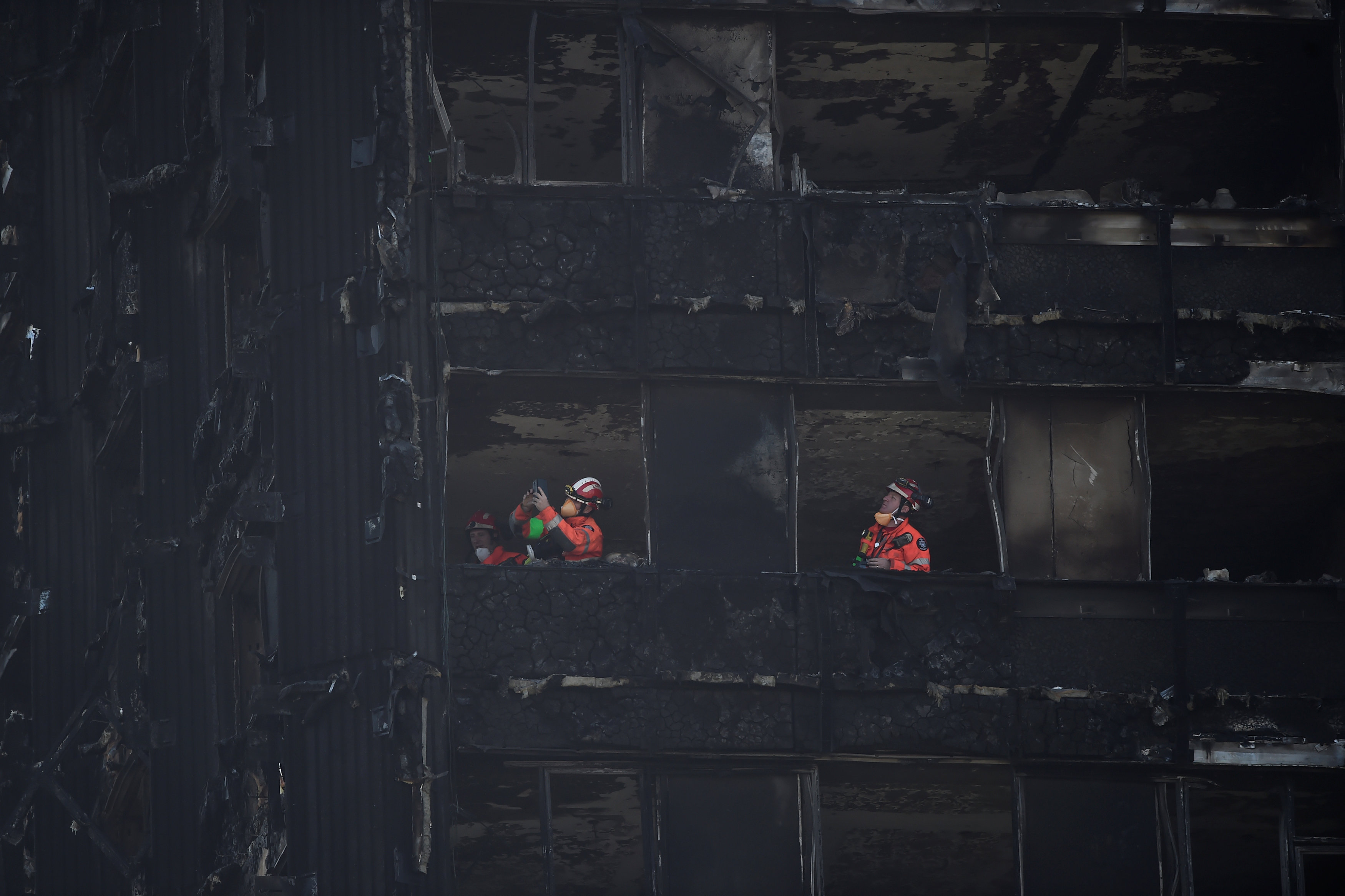 رجال الطوارئ يواصلون عملهم فى البرج المحترق