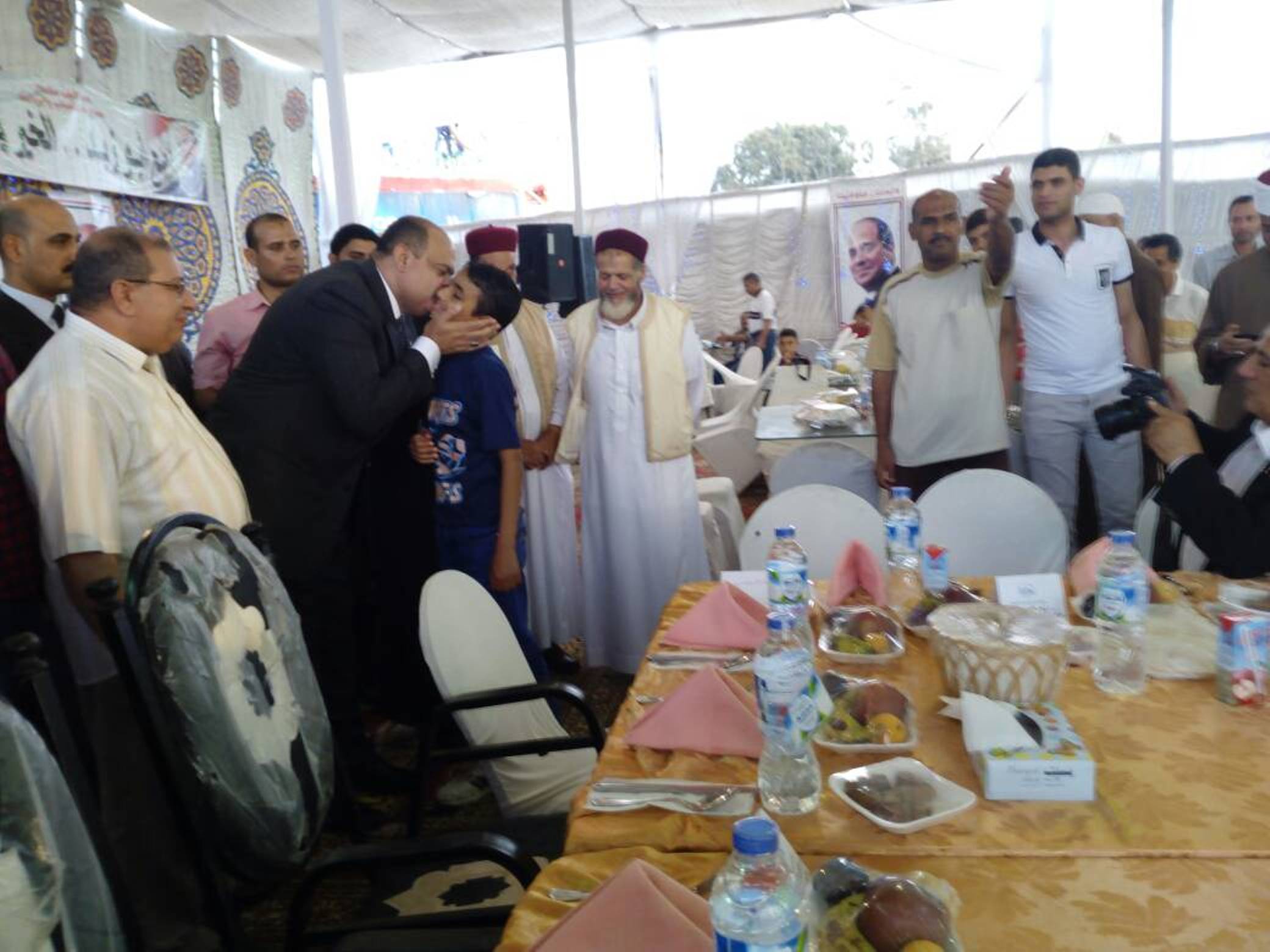 اللواء علاء ابو زيد يقبل طفل يتيم اثناء اهدائه تابلت