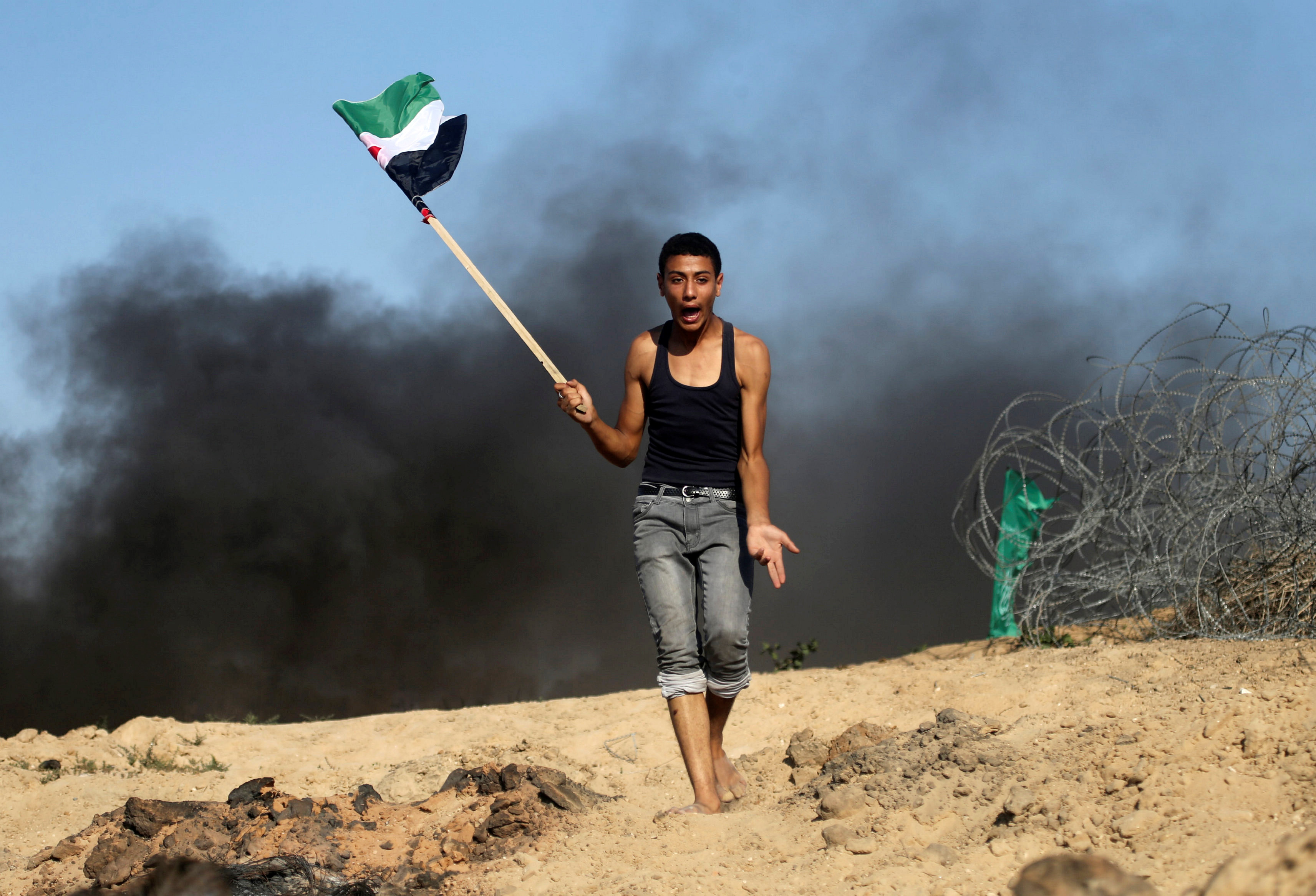 شاب يرفع العلم الفلسطيني