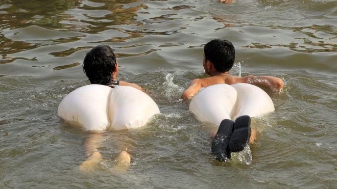 طفلان يسبحان في مجرى في إسلام أباد