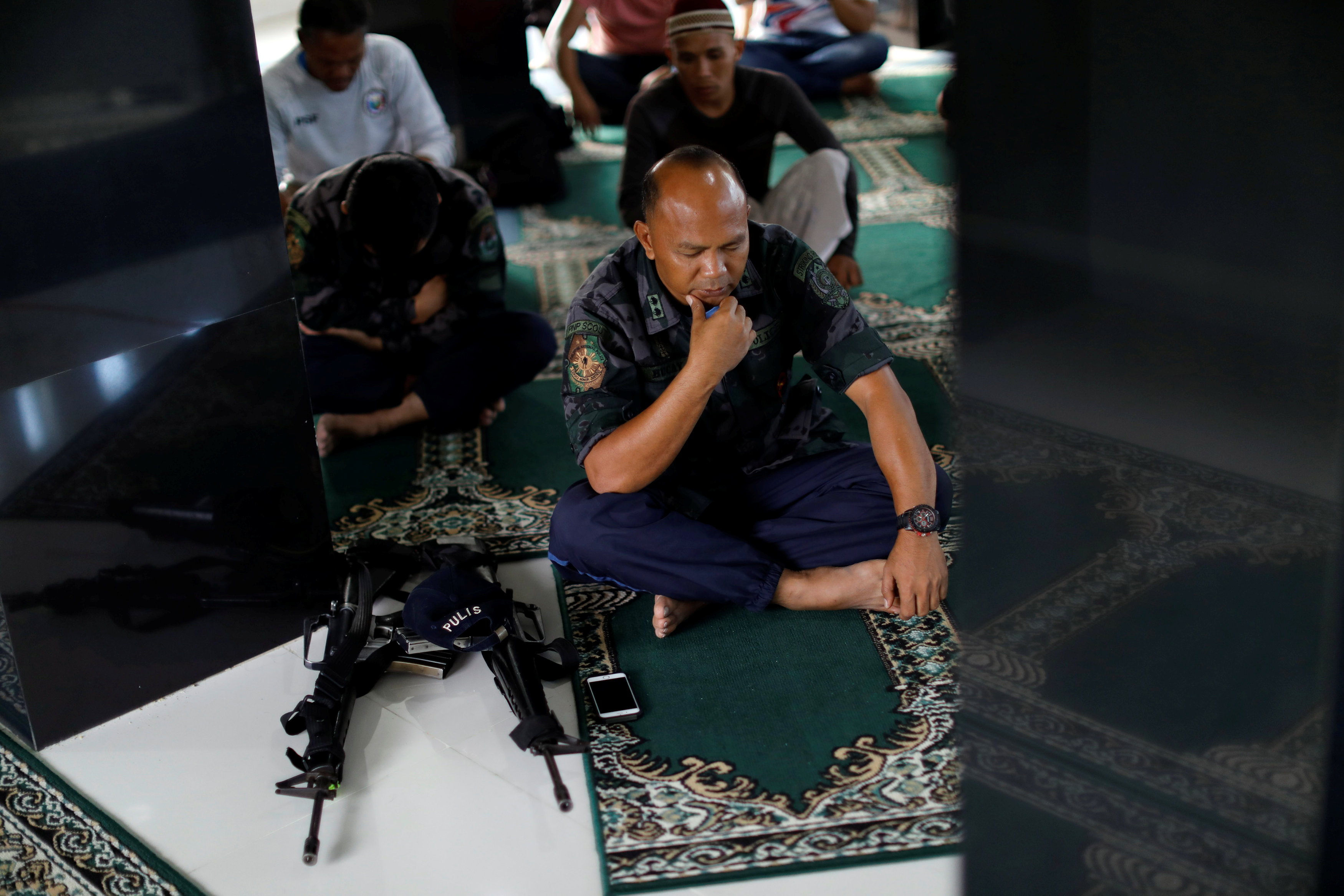 أحد القادة فى الجيش الفلبينى يصلى العيد بجوار سلاحه