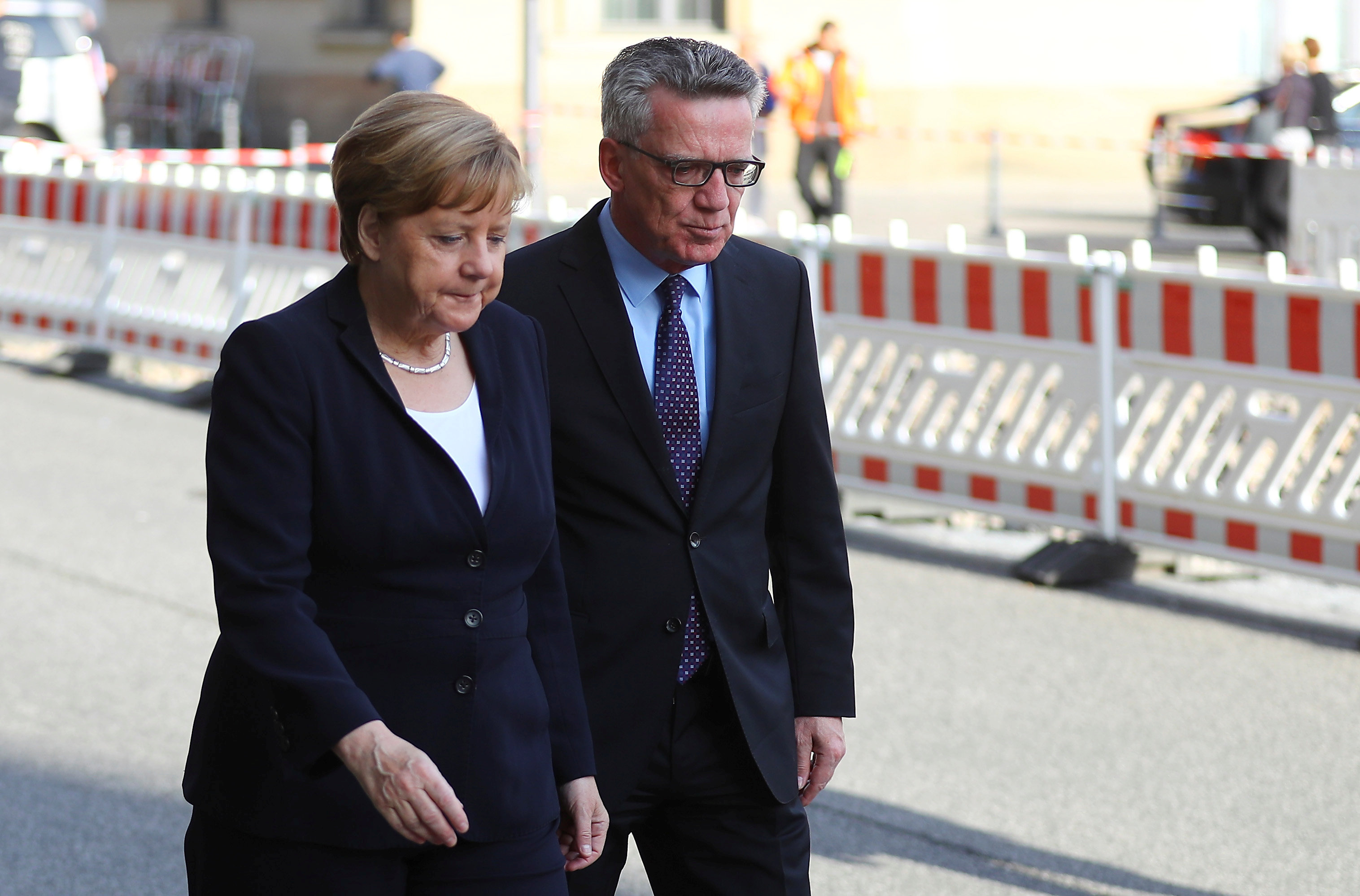 وزير الداخلية الألمانية يسير مع ميركل