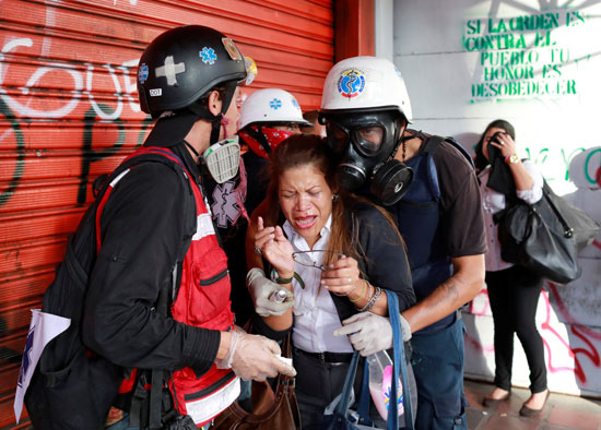 المتظاهرون ينقذون سيدة اصيبت بالاعياء نتيجة للغاز المسيل للدموع