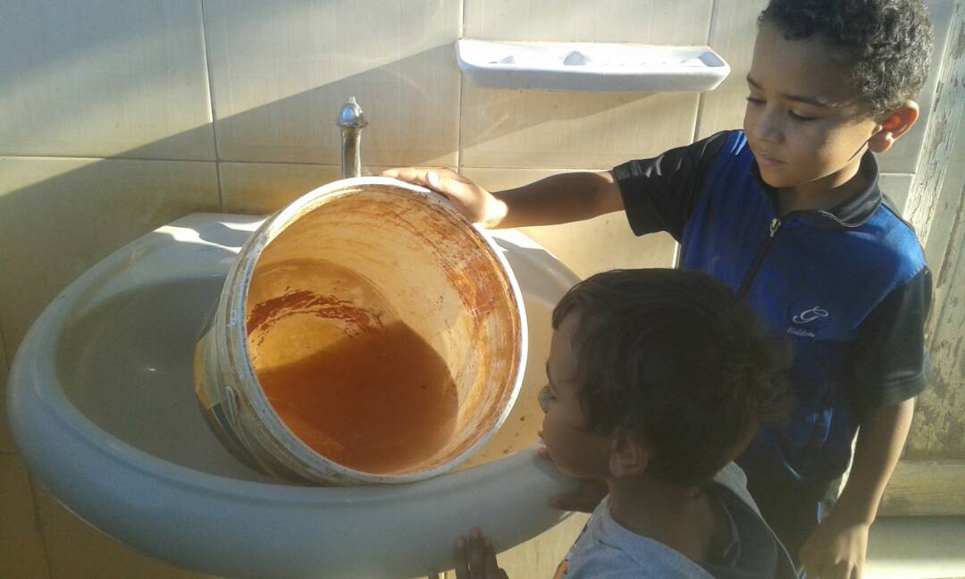 طفل يظهر مدى تلوث المياه