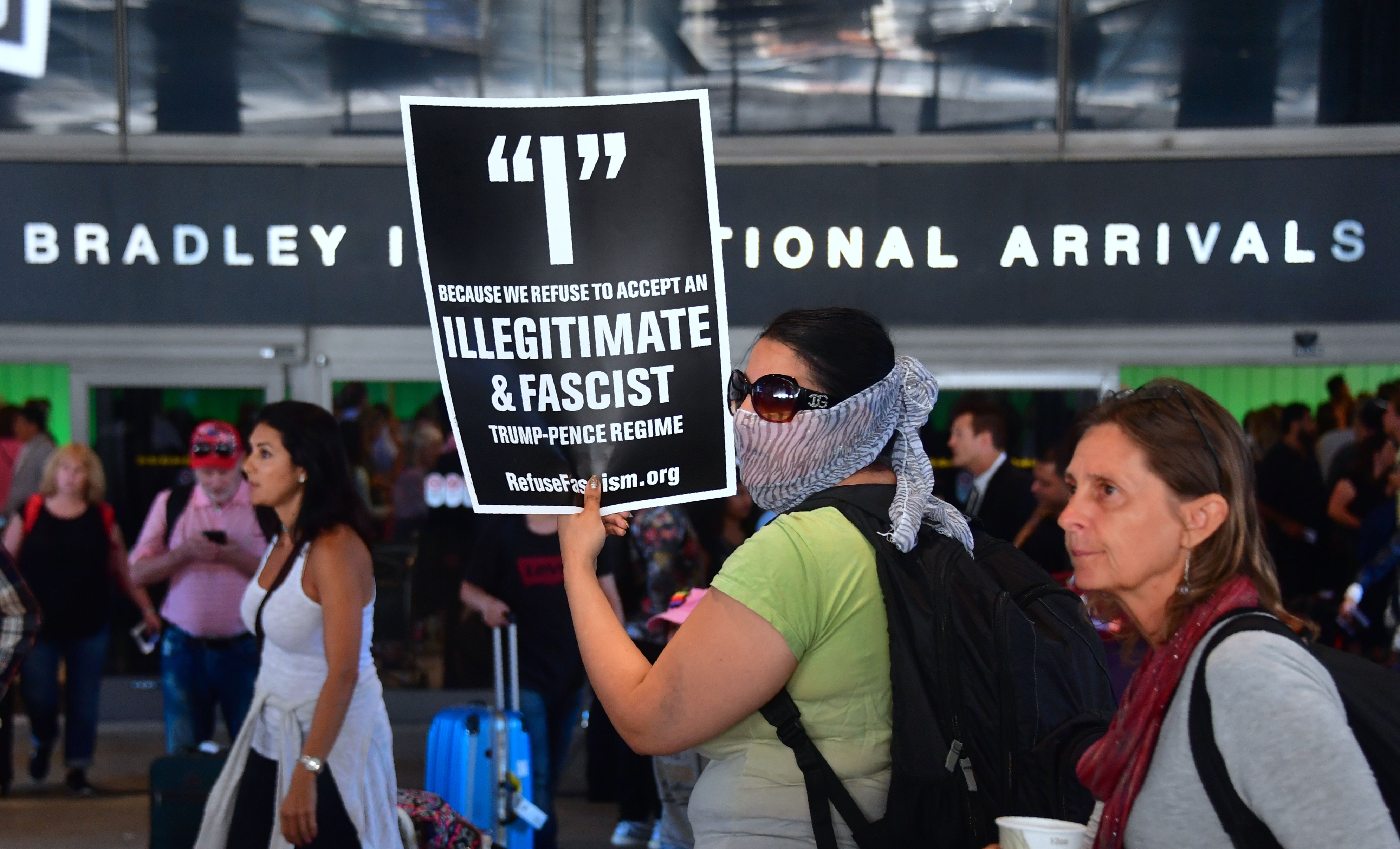 ناشطون يحملون لافتات خارج قسم الوافدين الدوليين في مطار لوس أنجلوس الدولي