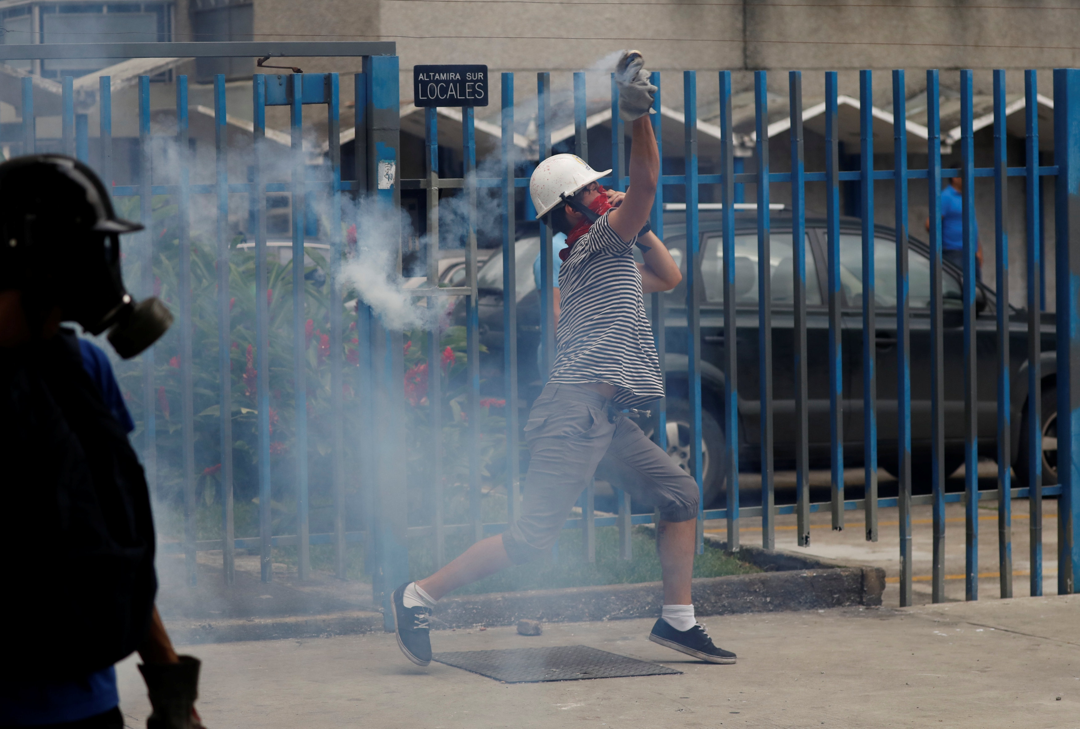 أحد المتظاهرين يستخدم الغاز المسيل للدموع