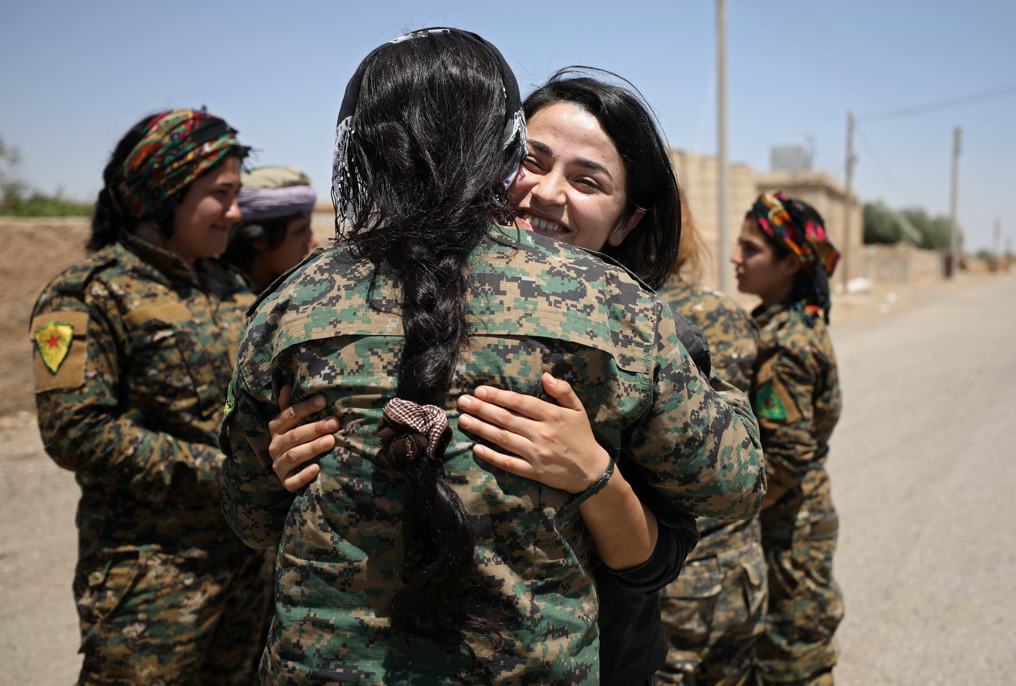 مقاتلة سورية تحتضن زميلتها بعد تحقيق التقدم فى الرقة