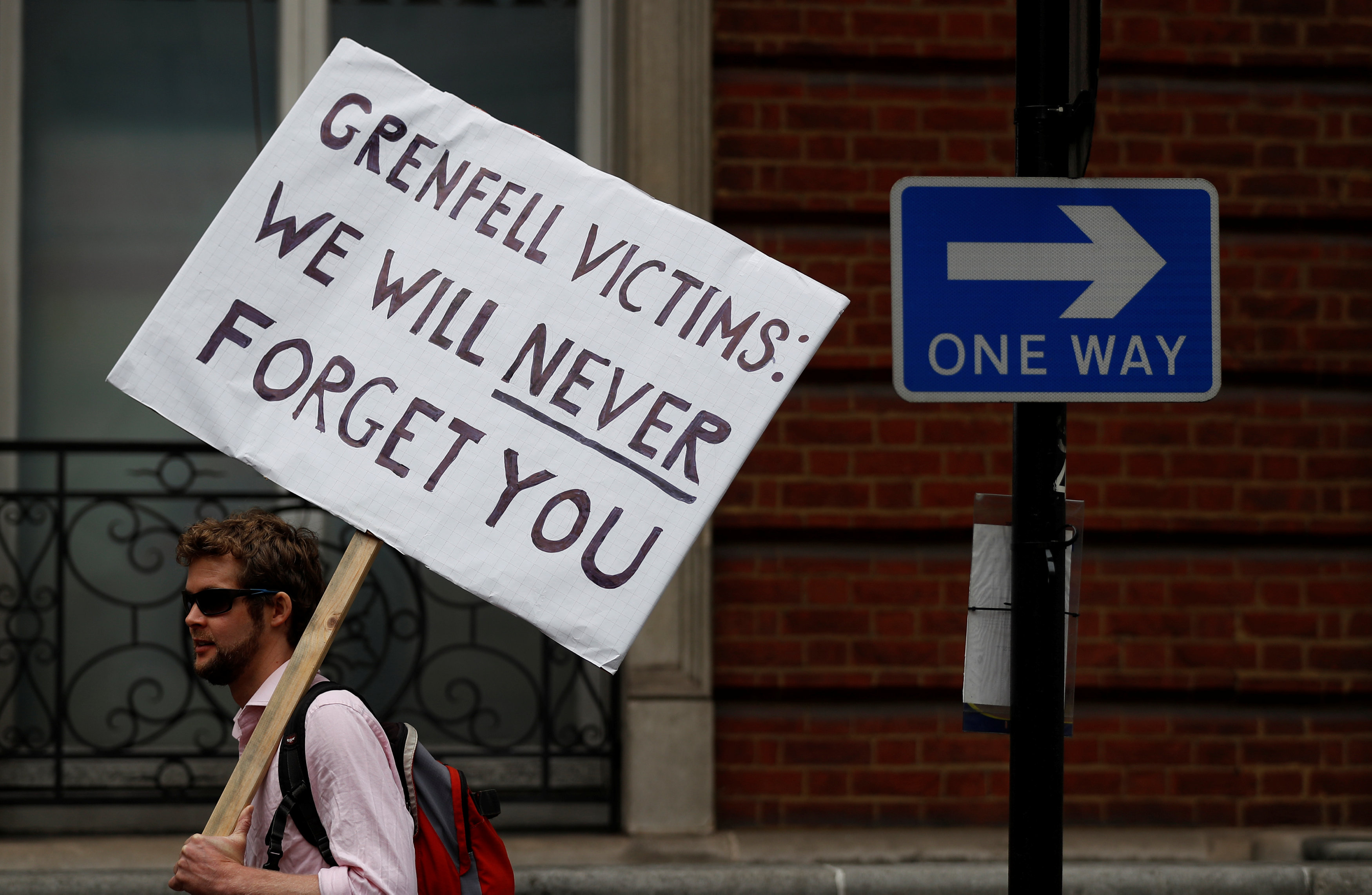 لافتة مكتوب عليها ضحايا جرنيفيل لن يسامحكونك