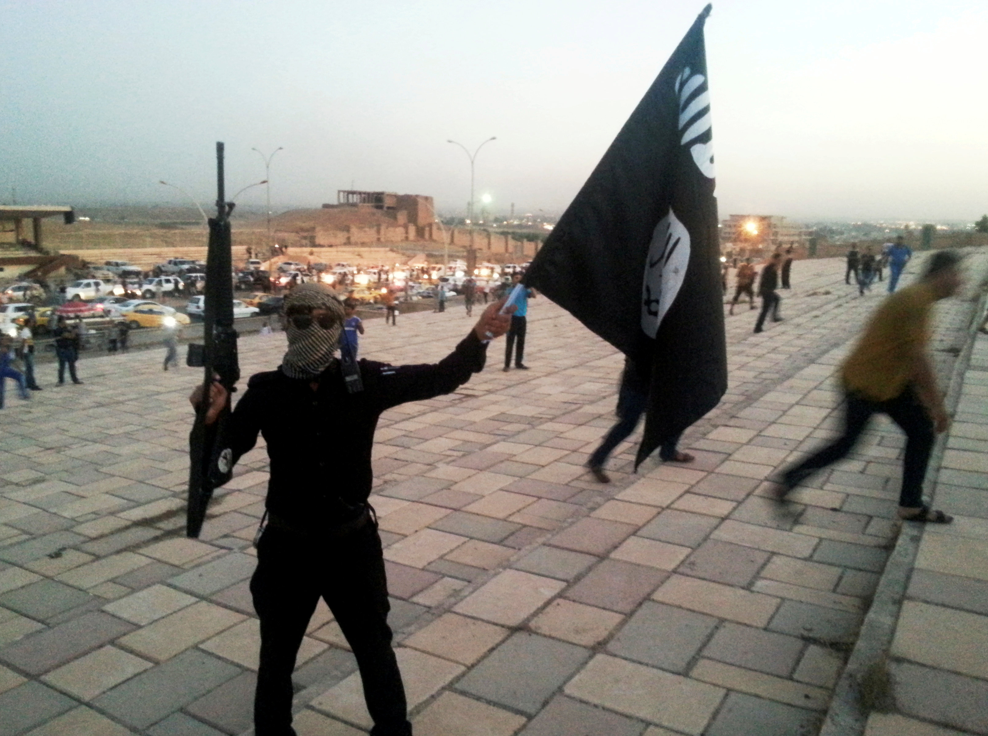 أحد عناصر داعش يلتقط صورة بعلم التنظيم