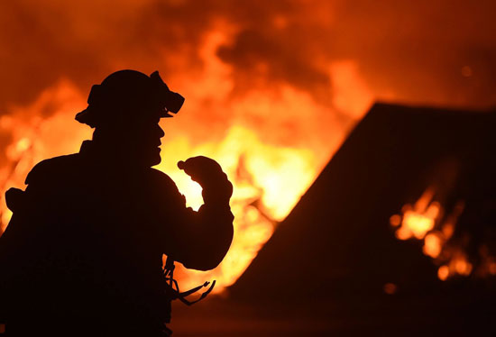 رجل إطفاء يعمل على إطفاء حرائق كاليفورنيا