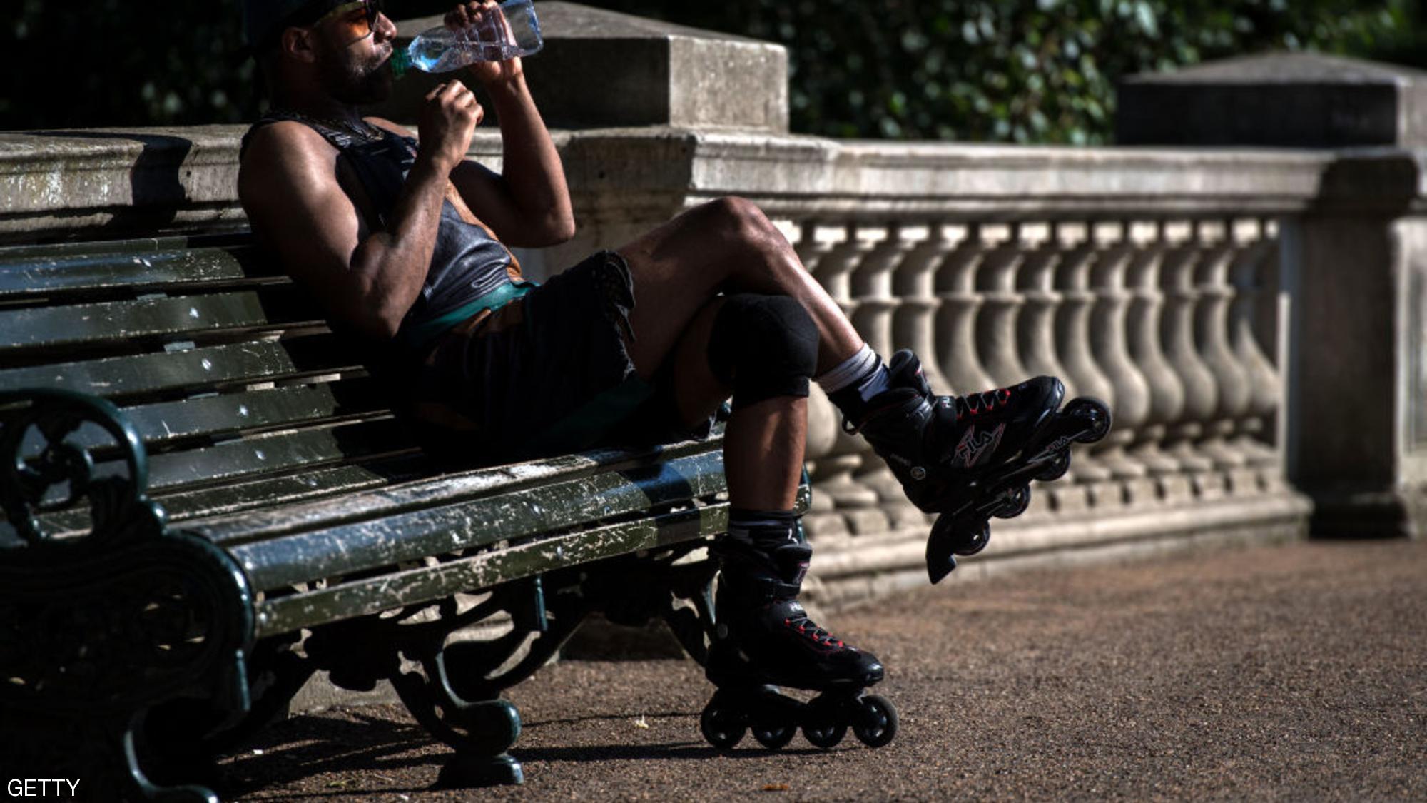 وآخر يأخذ استراحة لشرب الماء في متنزه هايد بارك وسط لندن