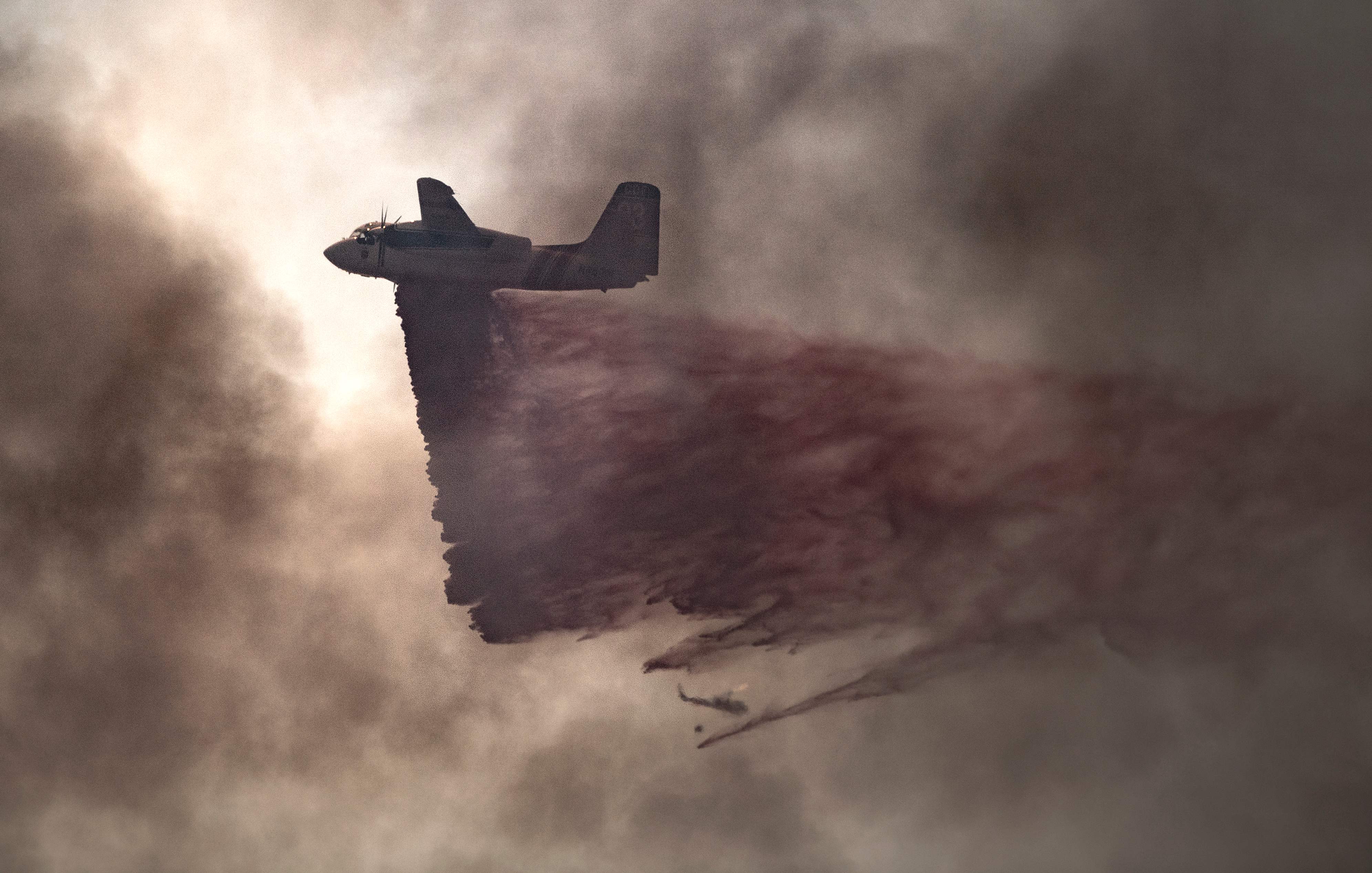 طائرة تقصف مسحوق الإطفاء لاخماد حرائق كاليفورنيا