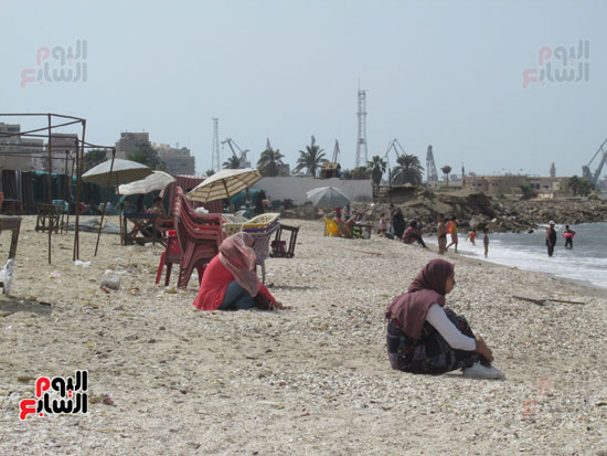  فتاتان من المصطافين تجلسان على قواقع شاطئ بورفؤاد