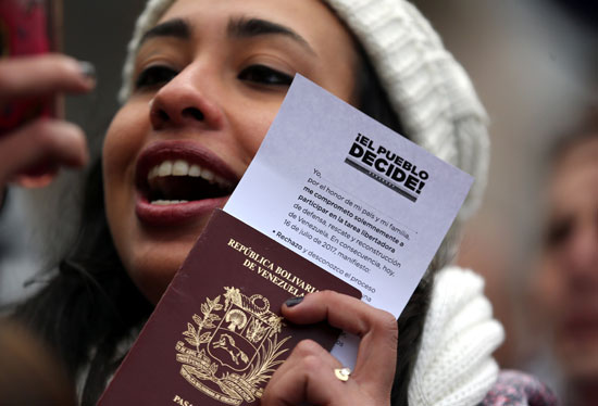 فتاة فنزويلية ترفع جواز السفر خلال الاستفتاء