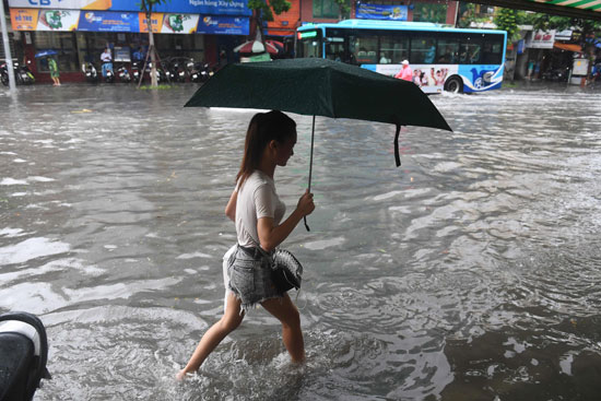 فتاة-تحمل-شمسية-فى-شوارع-فيتنام-لحمايتها-من-الأمطار