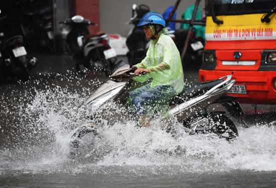 رجل-يسير-بدراجنه-النارية-وسط-مياه-الأمطار