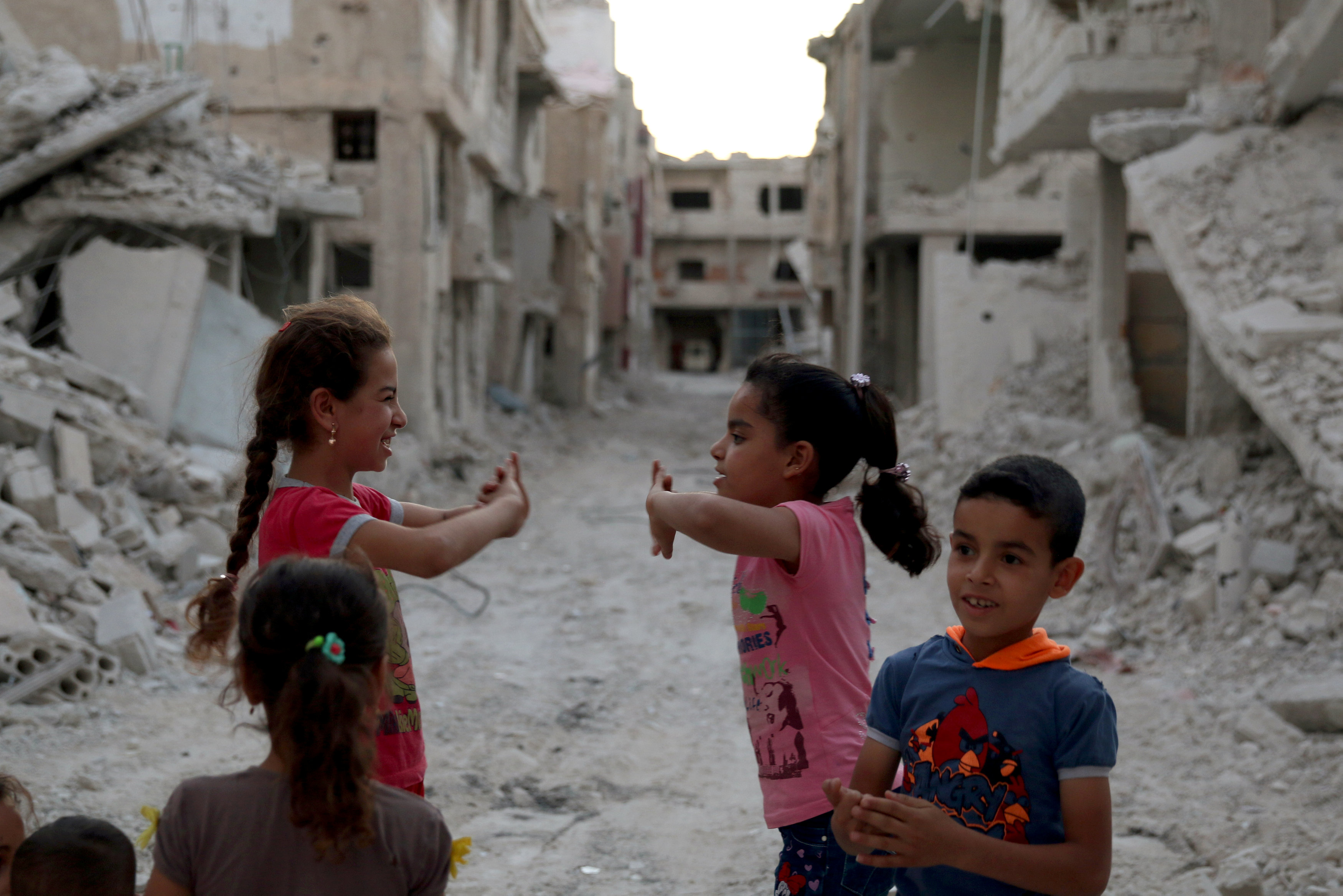 أطفال سوريون يلعبون وسط أنقاض الحرب